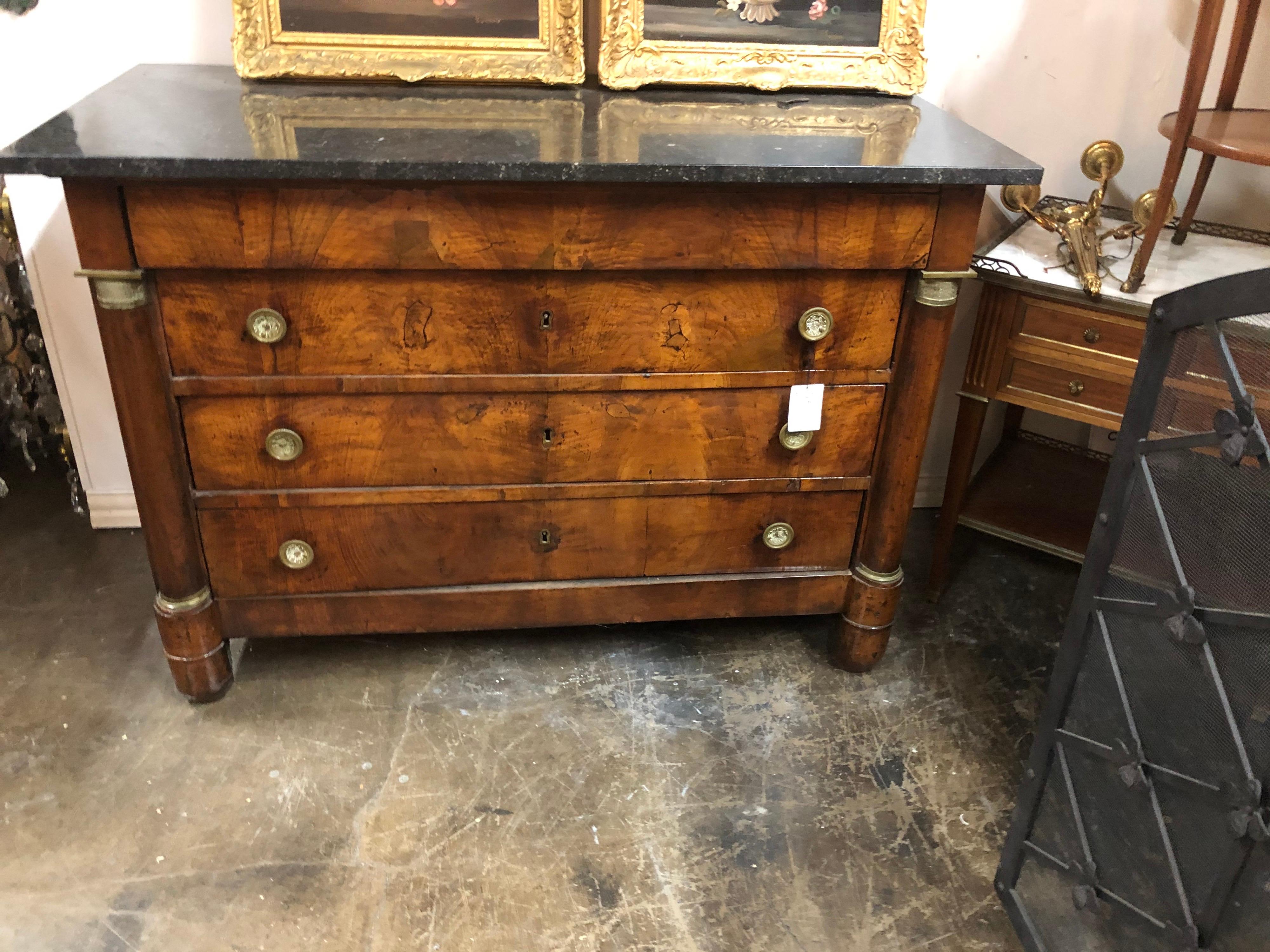 Very fine 19th century French Empire figured walnut commode. The black marble top above three beautifully patinated drawers with brass pulls and flanked by turned columns with brass accents.

Period piece,

circa 1850.

Perfect for traditional