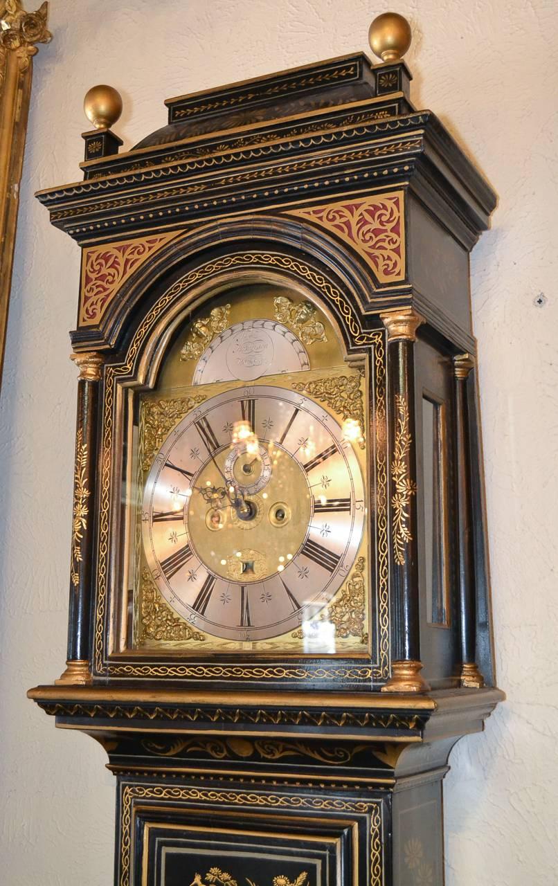 Marvelous English Chinoiserie decorated tall case clock circa 1860. Beautifully adorned with classic gilt oriental landscape motifs, and topped with globe finials.  Clock dial signed Thomas Hutchinson Worksop. 