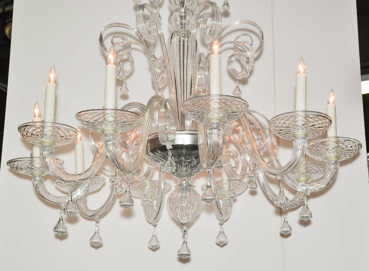 Gorgeous Italian ten-light handblown glass chandelier in elaborate scrolling motif. Having graceful scrolling arms, impressive central column and beautifully accented with blown glass drop prisms. 
