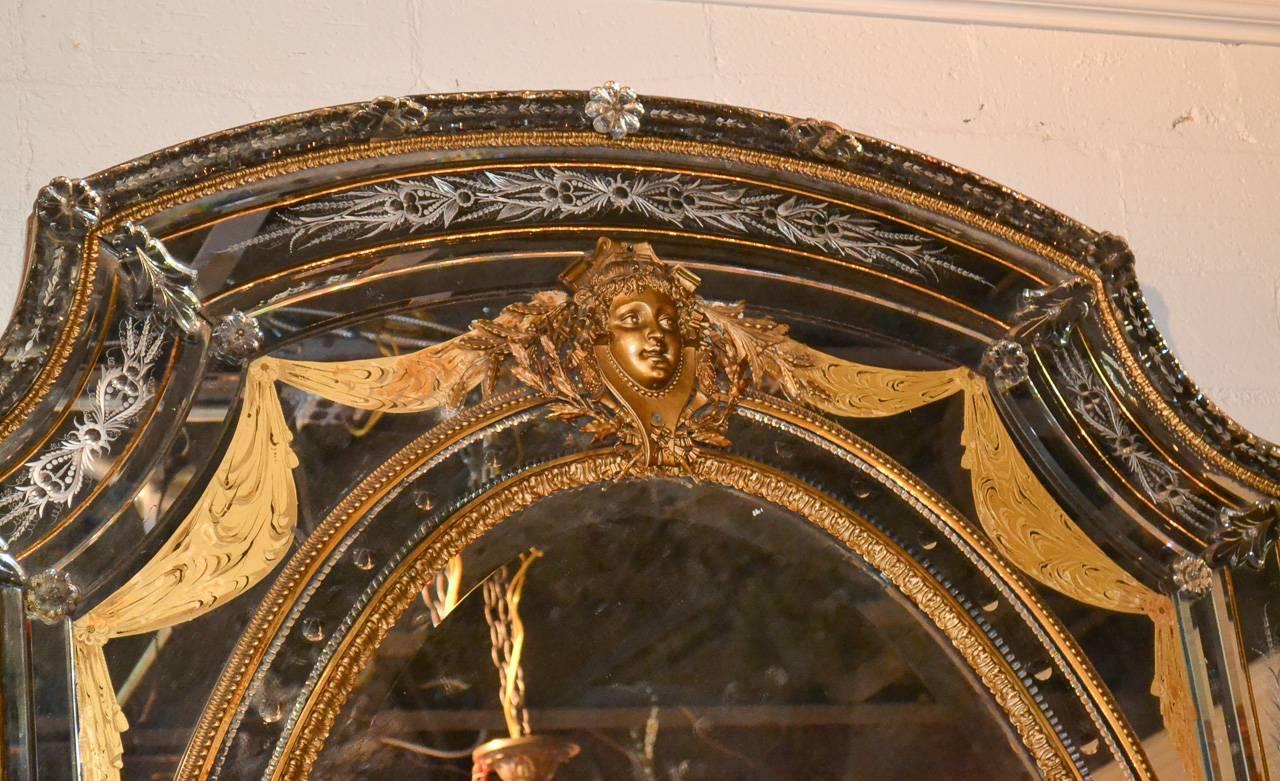 Monumental 19th century French mirror with gilt bronze mounts, circa 1870. Having wonderful etched glass details in foliate motif, central oval mirror with beveled glass, adorned with mask of female and acanthus leaf accents, and with sections of