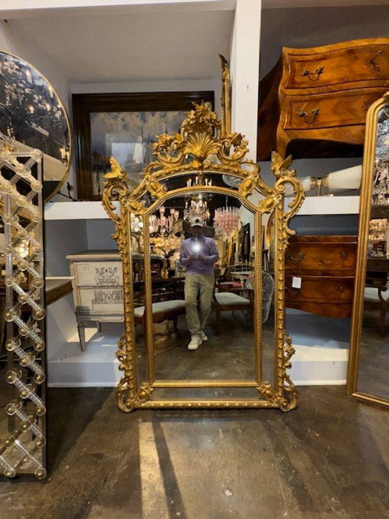 Lo specchio francese Luigi XV del XIX secolo con uccelli presenta uno specchio in legno intagliato e dorato con uccelli. Questo specchio antico presenta dettagli intricati, tra cui disegni di uccelli ornati che aggiungono un tocco di raffinatezza e