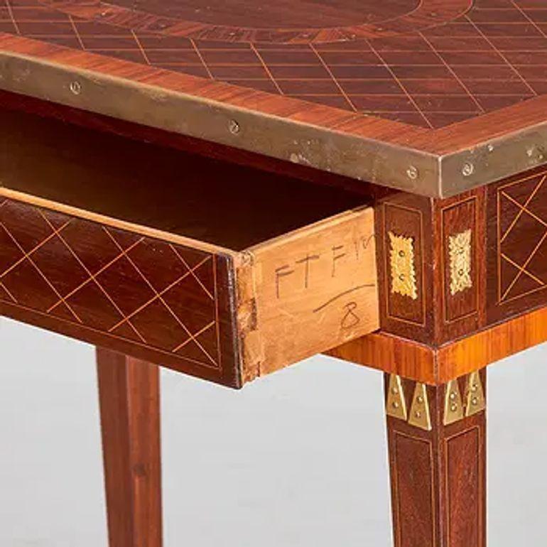 This 19th Century Baltic Neo-Classical Mahogany Side Table with Brass Inlay is a stunning piece of furniture that exudes elegance and sophistication. Made from luxurious mahogany with intricate brass inlays, this side table embodies the classic and