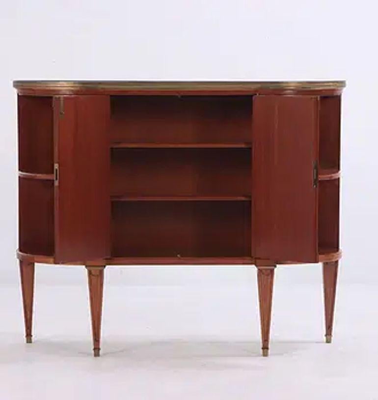 The Mid-Century Jansen Style Mahogany Server is a vintage piece of furniture that exudes a timeless elegance. Crafted from luxurious mahogany, this server is perfect for adding a touch of sophistication to any dining or living space. The Jansen