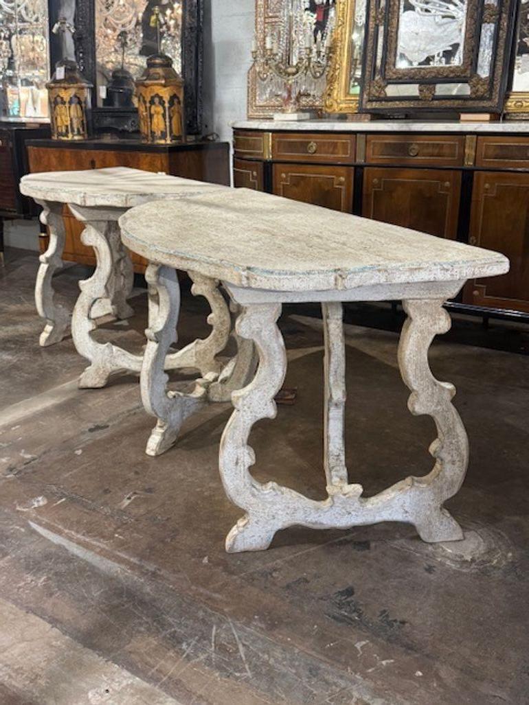Pair of Italian Tuscan style carved and painted consoles. These consoles often feature acanthus leaves, scrollwork, and timeworn finishes that evoke centuries of Italian artistry. Circa 1940. 51W x 26D x 31.5H