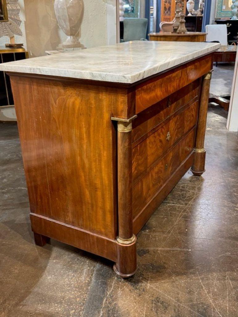 19th century French Empire flame mahogany commode with Carrara marble. This commode is the epitome of early 19th-century grandeur, blending rich materials with architectural symmetry Circa 1850. 50W x 24D x 36H
