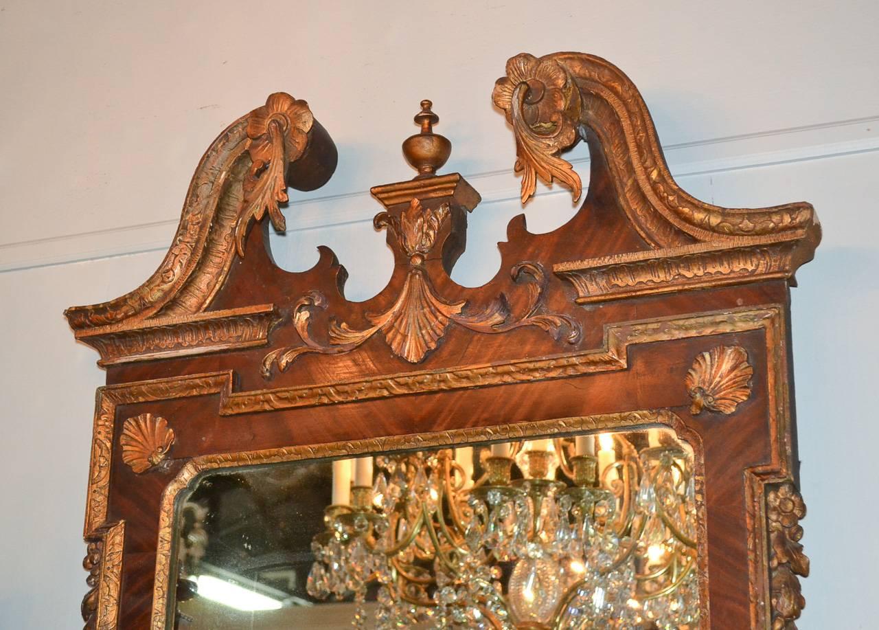 Superb 18th century English Chippendale carved wood looking glass. Having split arch pediment and finial, a carved mask of lion on lower portion, and accented in carved acanthus leaf motif. A handsome piece for any design!

 
