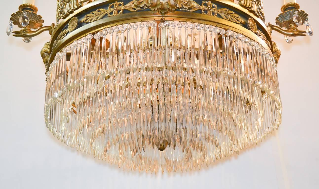 Exceptional 19th century French Empire gilt bronze and crystal twelve-light chandelier. Having finely cast bronze detailing, elegant arms in swan and lyre form, beautiful central column, and accented with bronze strands. 
   