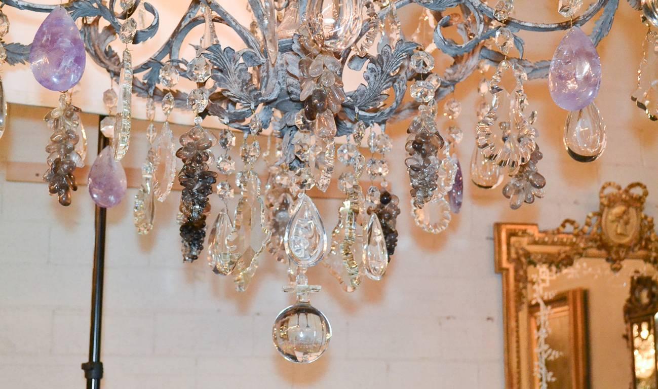 Exceptional custom French style iron and rock crystal chandelier. Having beautiful painted iron frame in leaf and swag motif, amethyst grape clusters, bobeche and candle cups in floral motif, 16 lights, and a wonderful cut-crystal central column. 