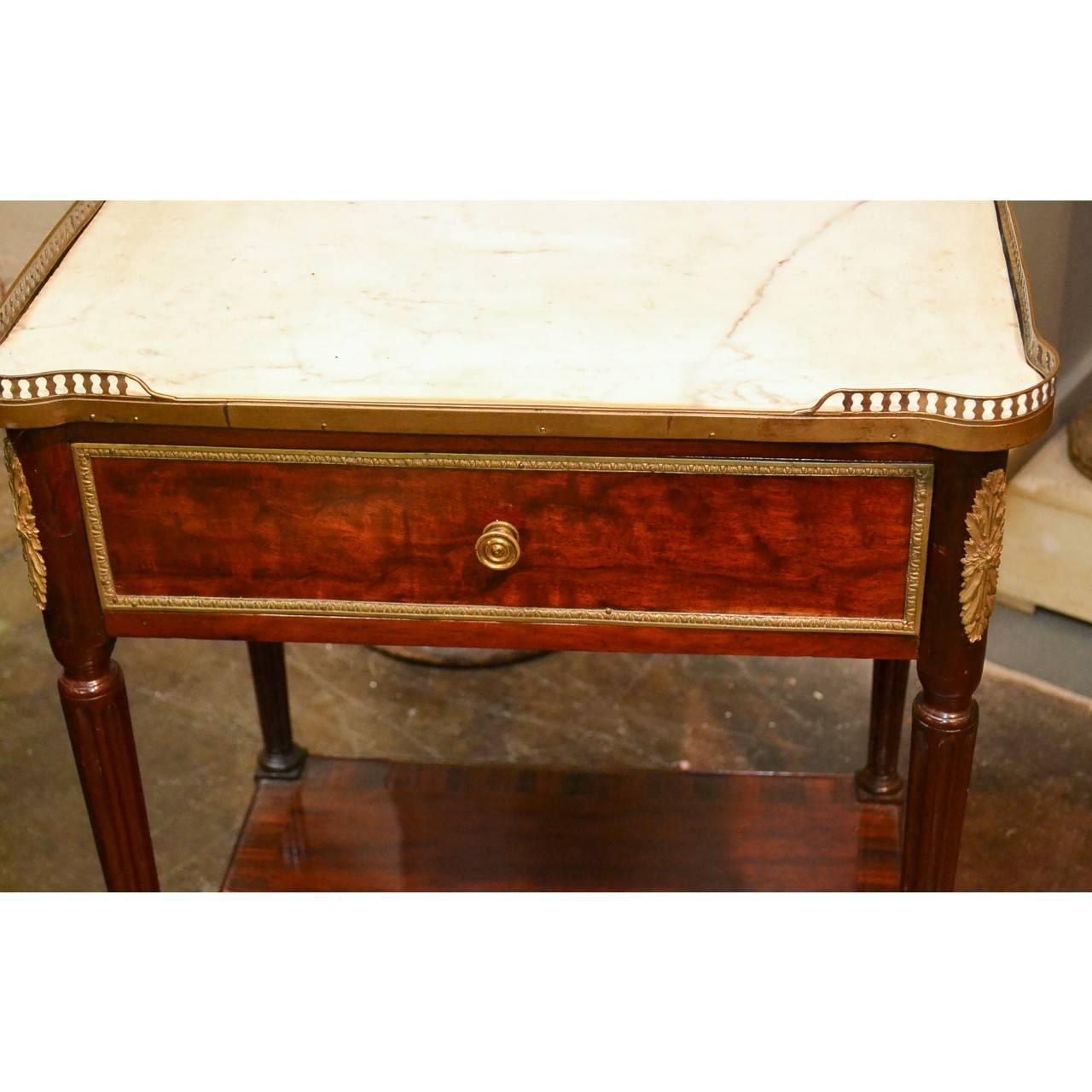 19th century French Louis XVI style mahogany side table with Carrara marble top and brass gallery,
circa 1890.