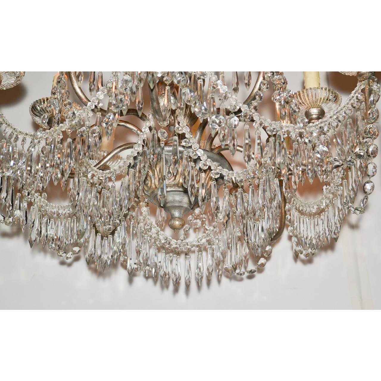 Uniquely designed early 20th century Italian olive-green painted and carved wood ten-light chandelier with muted gold highlights. The entire with draped bead crystal drops and enhanced with an abundance of spear-cut crystal prisms.
