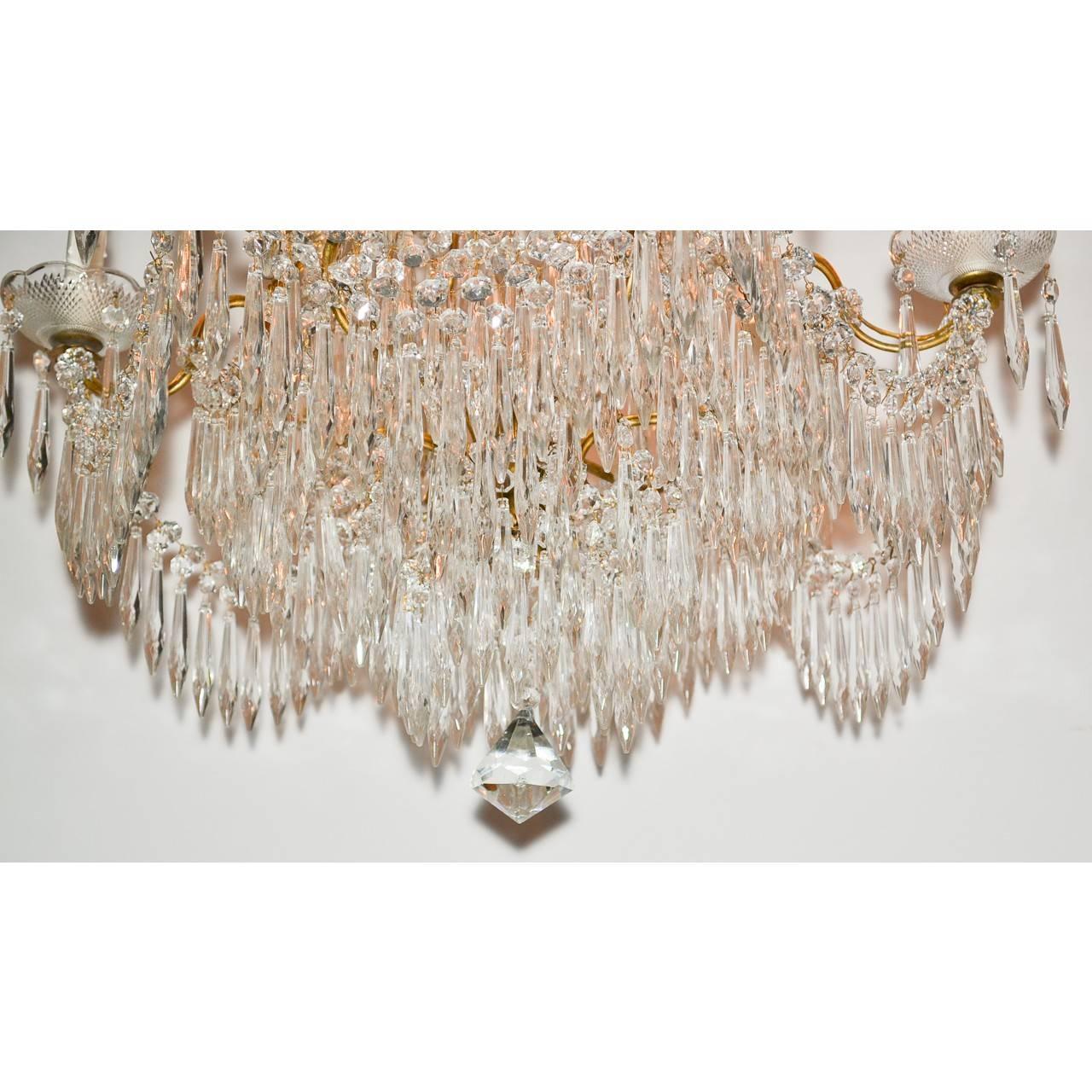 Sparkling midcentury French crystal and gold gilded six-light chandelier lavished with beautifully cut and faceted beaded and spear designed prisms and flower petals. Take notice of the superb scallop edged bobeches,

circa 1940.