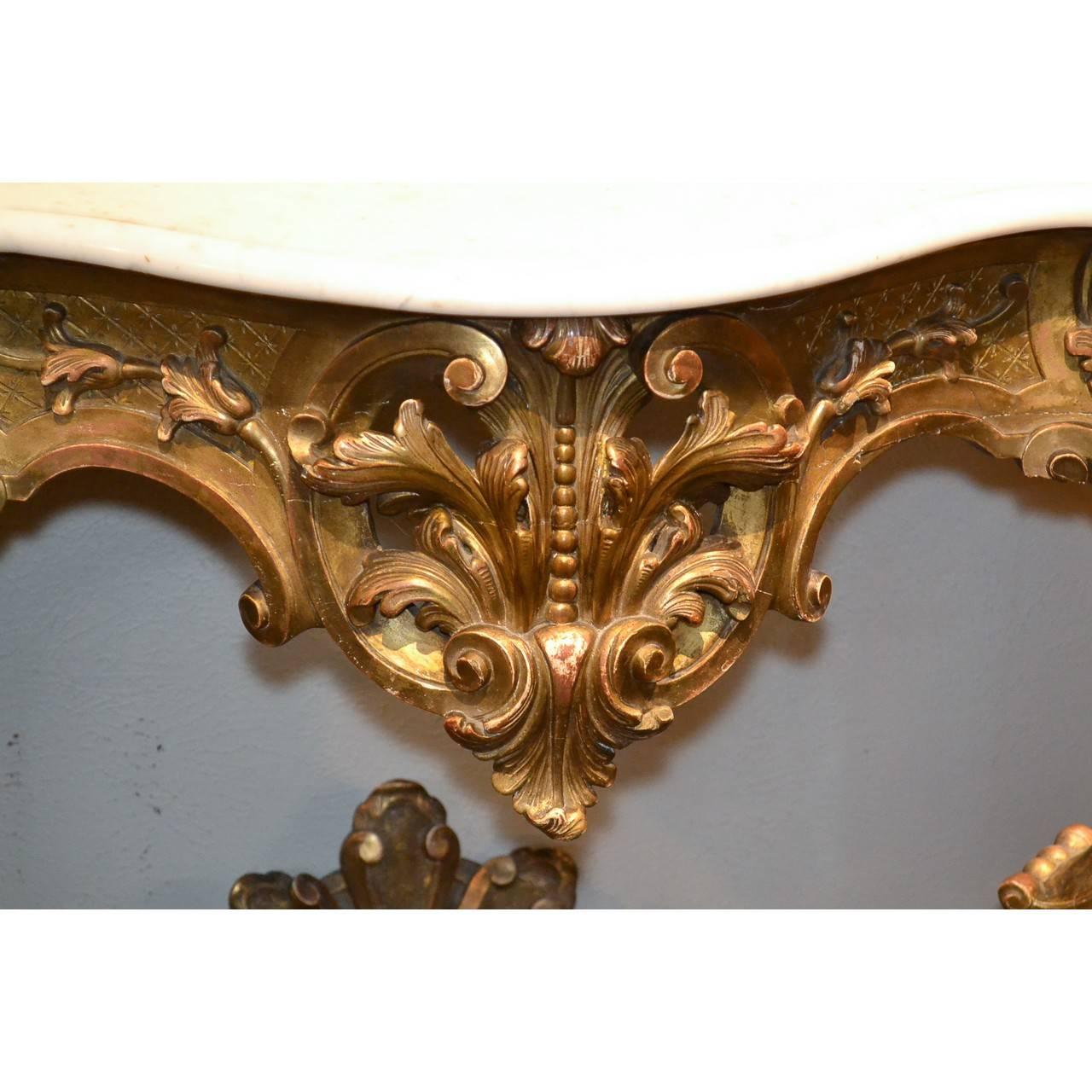 Phenomenal 19th century French carved giltwood and Carrara marble serpentine fronted console in the Rococo fashion, elaborately decorated overall with leaf sprays and scrolling foliage, circa 1860.

Size: 45.5