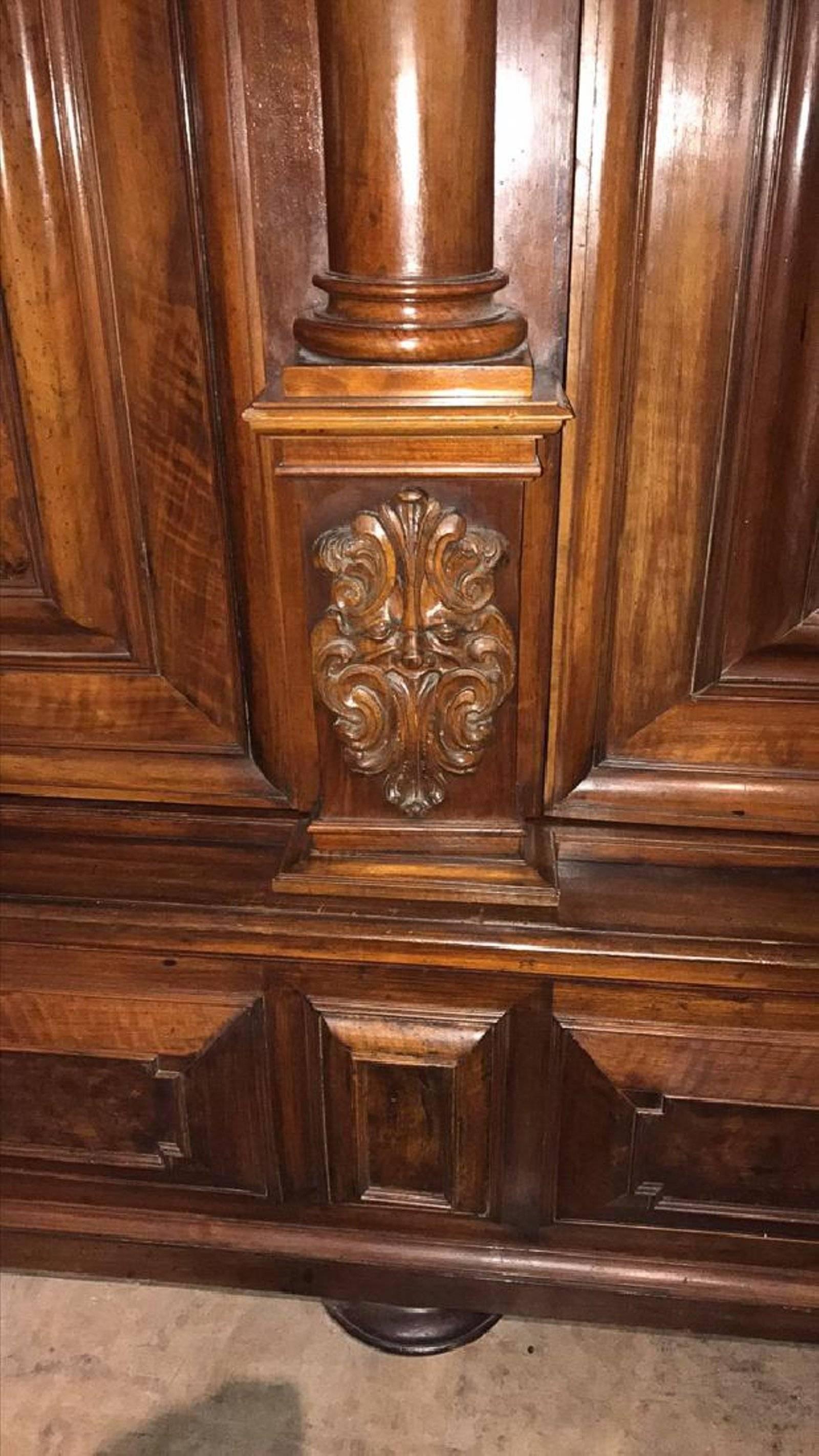 Very fine 18th century Italian Tuscan two-door cabinet with raised inset burled walnut panels. The bonnet with a carved acanthus and putti mask above turned columns with ionic and Tuscan capitals.

The lower most with intricate carvings of