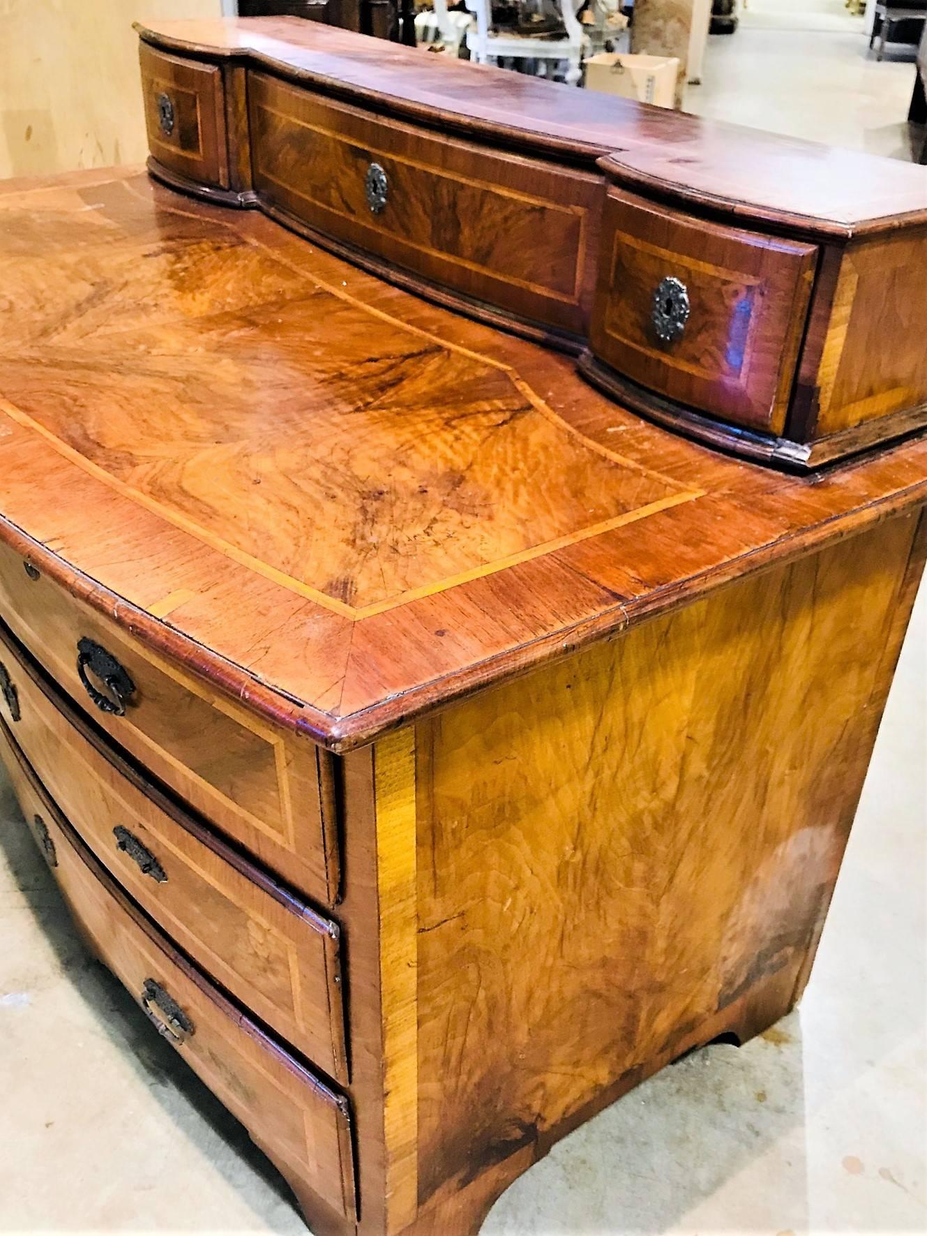 Scarce diminutive 18th century German three-drawer commode with shaped riser inset with smaller drawers.

This fabulous piece handcrafted of walnut banded veneer, satinwood string inlay and burled walnut panels. The drawers with fancy hand-wrought