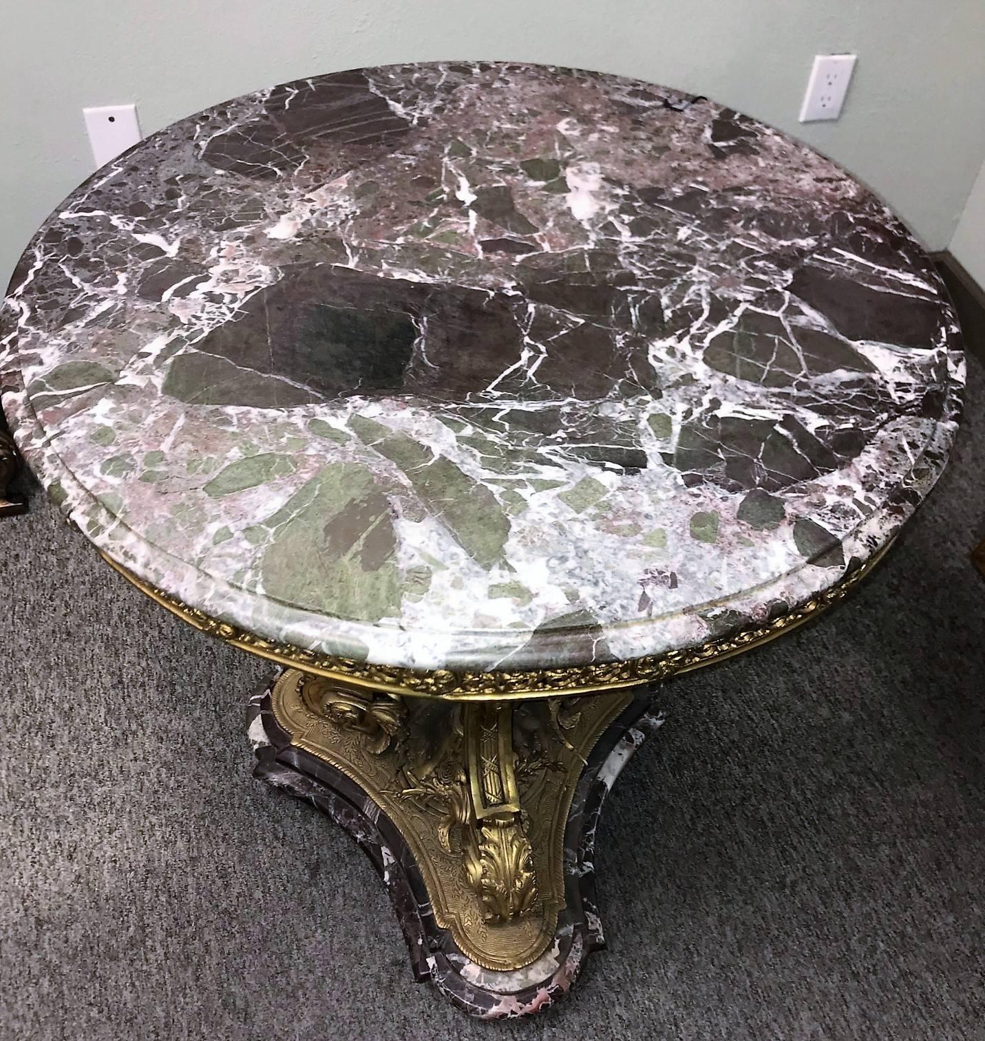 Outstanding quality antique French Rococo style side table or centre table with a gorgeous marble top in variegated colors of rouge, white and black. A finely detailed bronze filigree apron with spaced rosettes surrounds the top.

The shaped