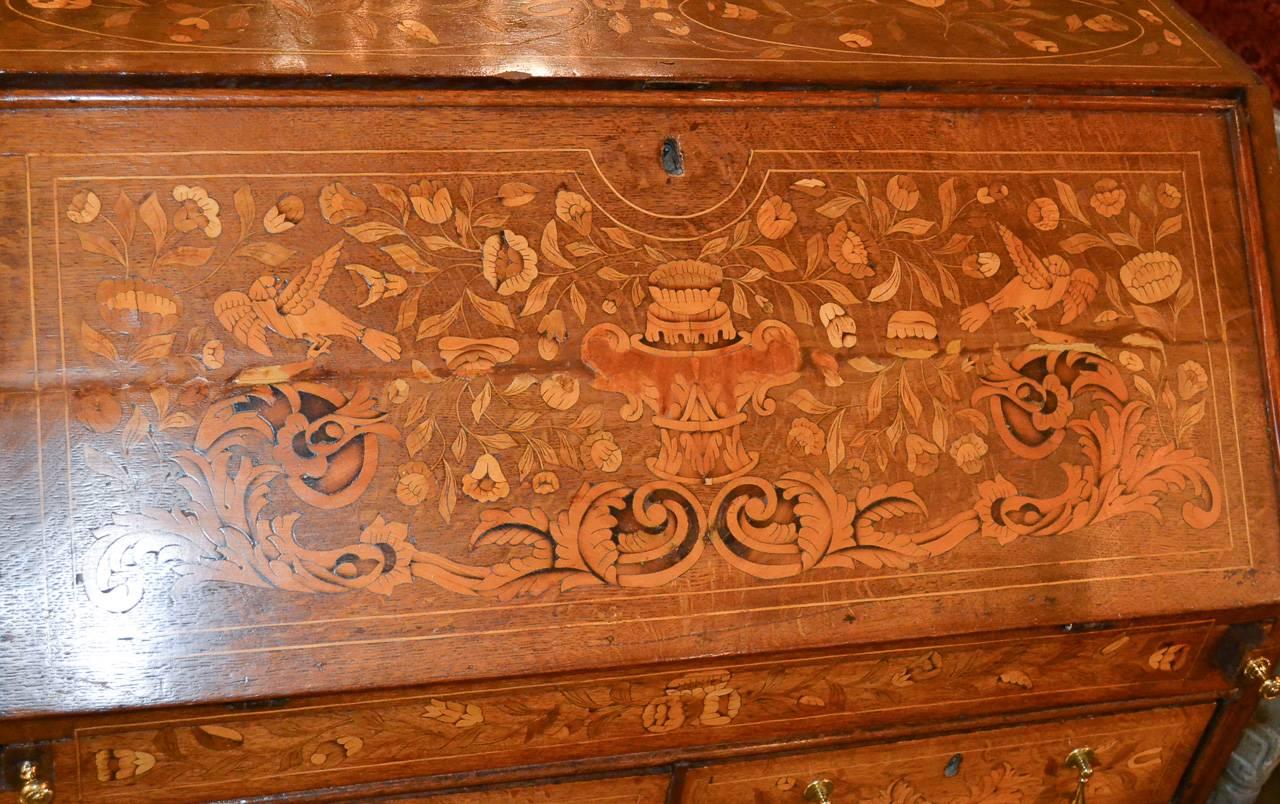 Marvelous 19th century Continental oak bureau with marquetry inlays. Having detailed and intricate inlays in floral and acanthus leaf motif, brass hardware, and lovely fitted interior. A charming piece for any design!