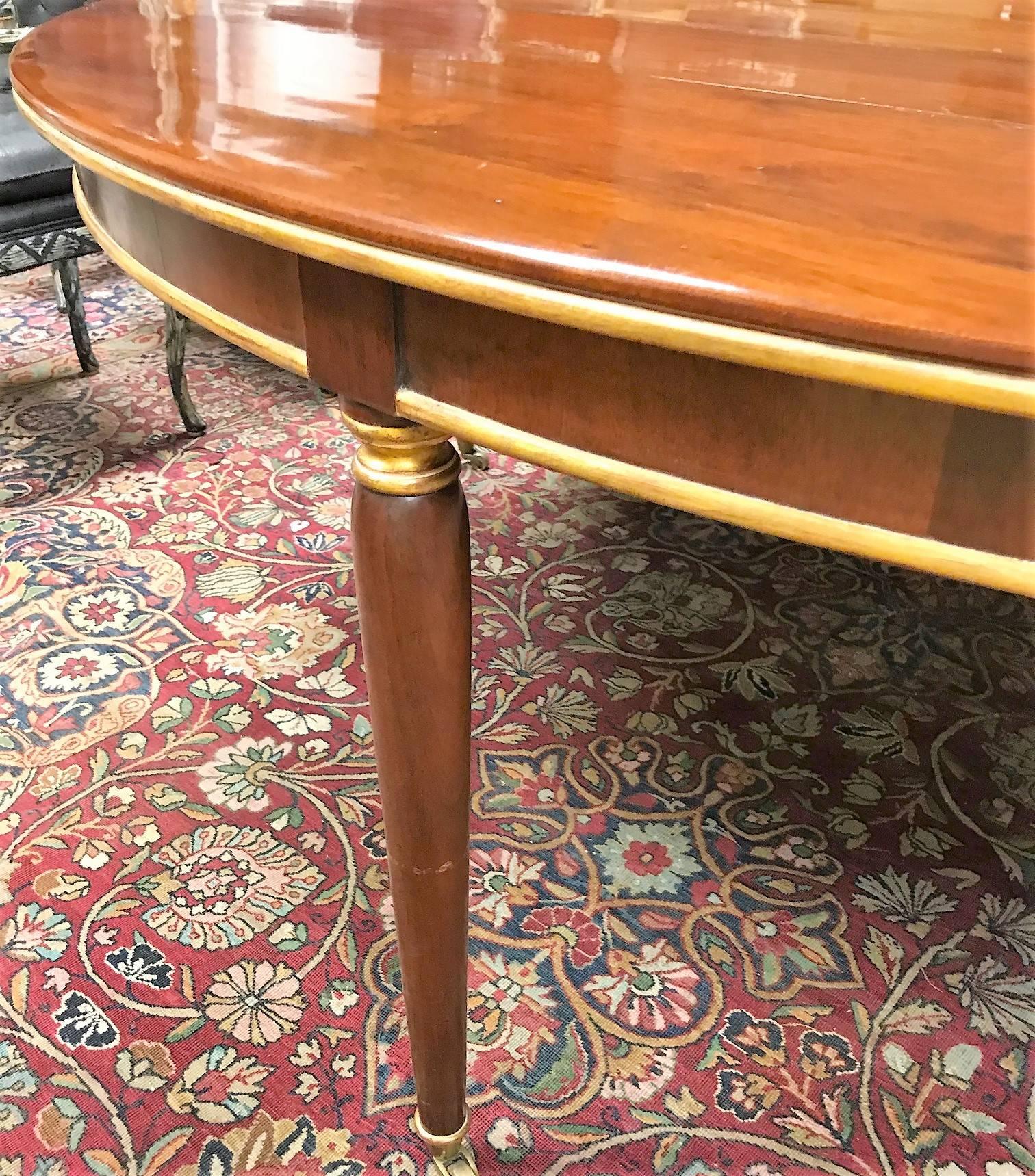 Very fine quality Louis XVI style conference table by renown furniture maker Dessin Fournir.

Custom crafted of exotic imported mahogany with parcel gilt accents and raised on turned and tapered legs with brass casters.

The table was removed from a