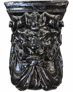 Par de ménsulas arquitectónicas de yeso pintadas de negro con motivos de leones, de principios del siglo XX