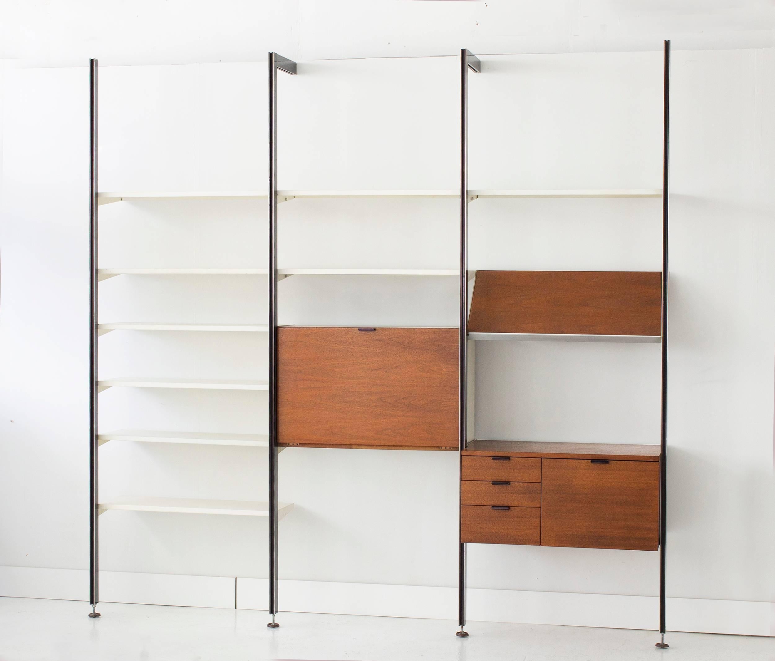 
Three bay George Nelson CSS unit with rare metal shelves. 
Includes ten white metal shelves, drop front cabinet, magazine display shelf and a four drawers cabinet.
Walnut elements have all been restored. 
Herman Miller, 1957 production.