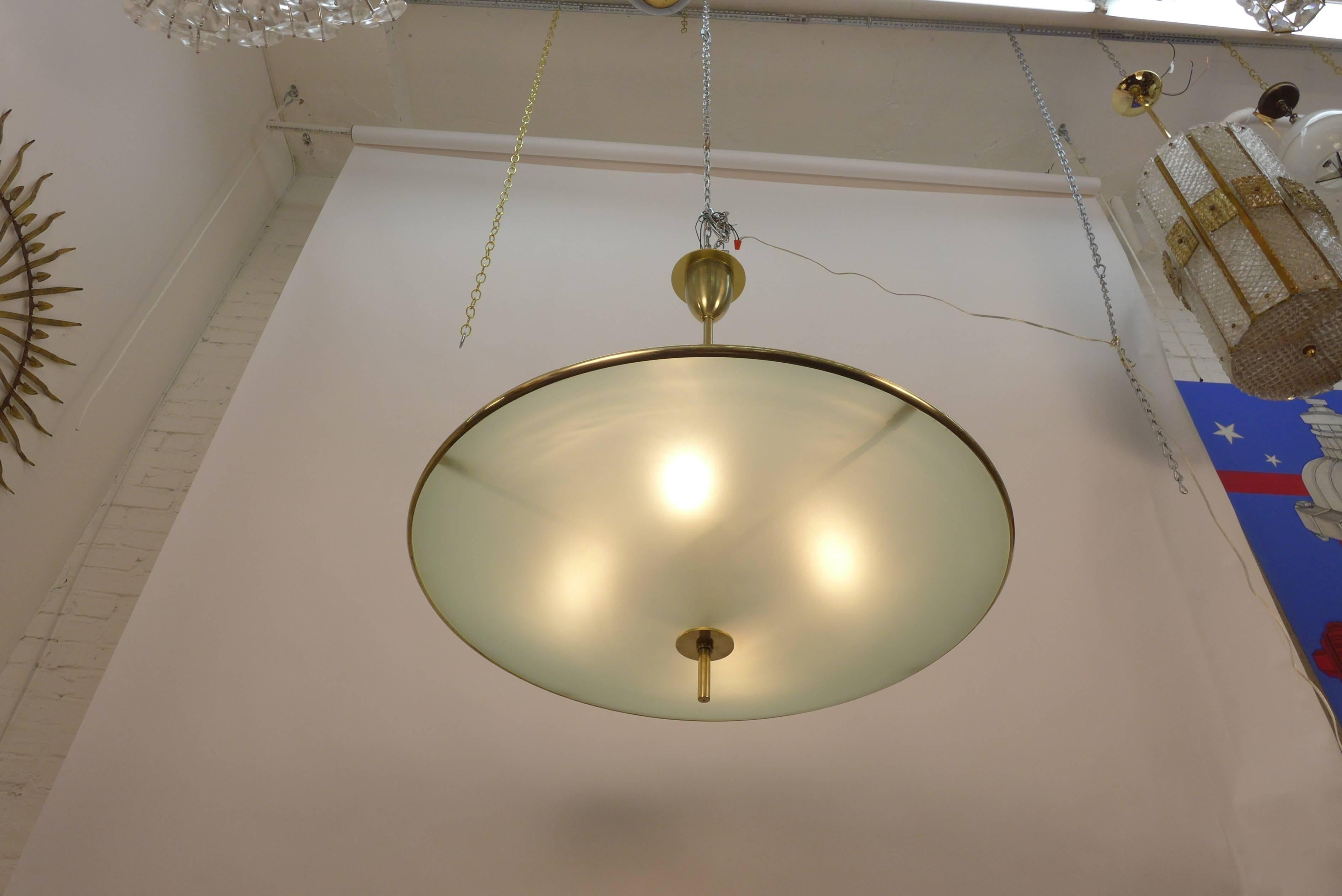 A very large pair of flying saucer chandeliers. They are made of solid brass and etched convex glass, each composed of two frosted glass domes.
Made to order.
Four regular sockets Max. 100 watts per socket.