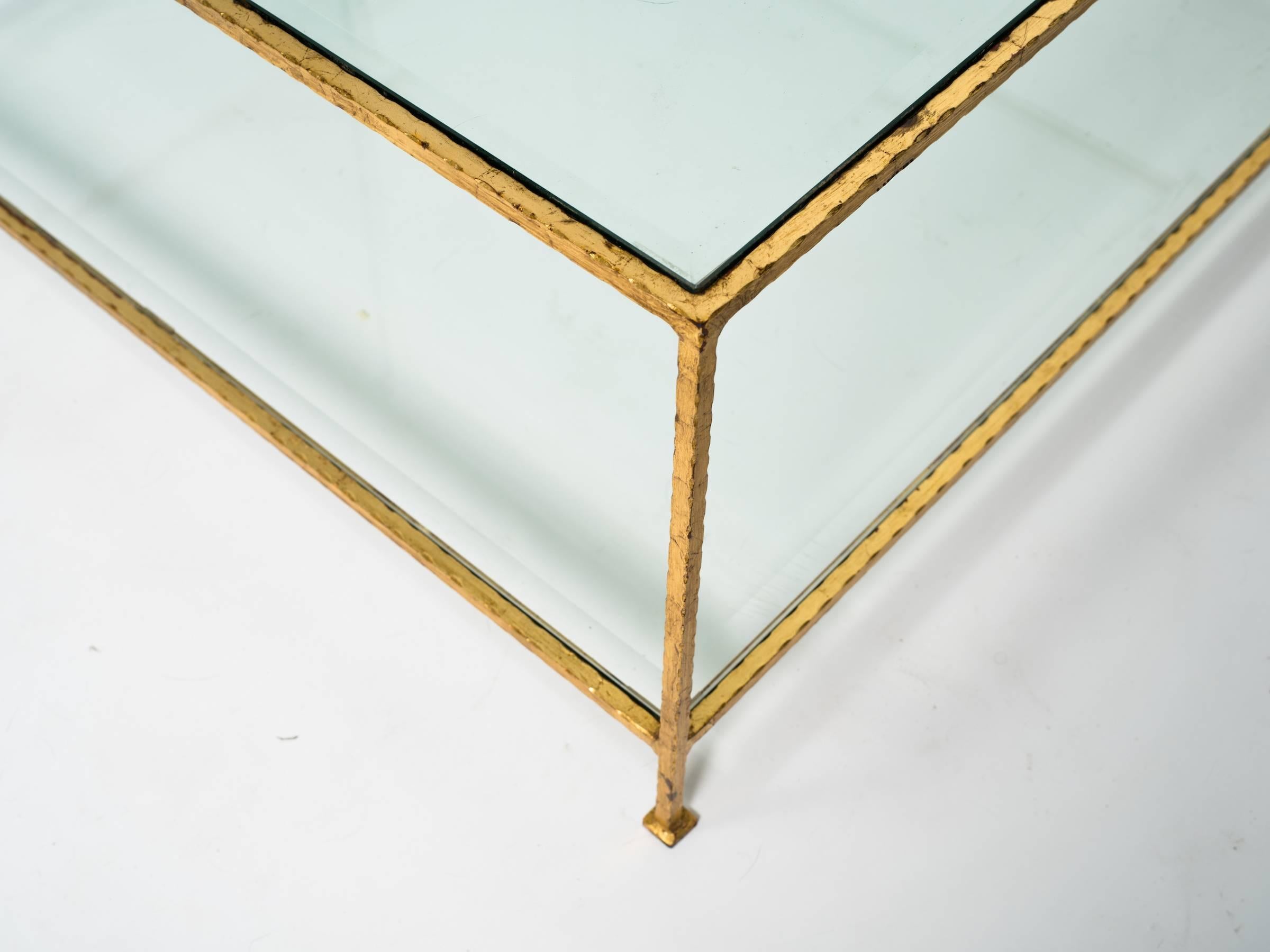 Two-tiered gilt iron coffee table with beveled glass.