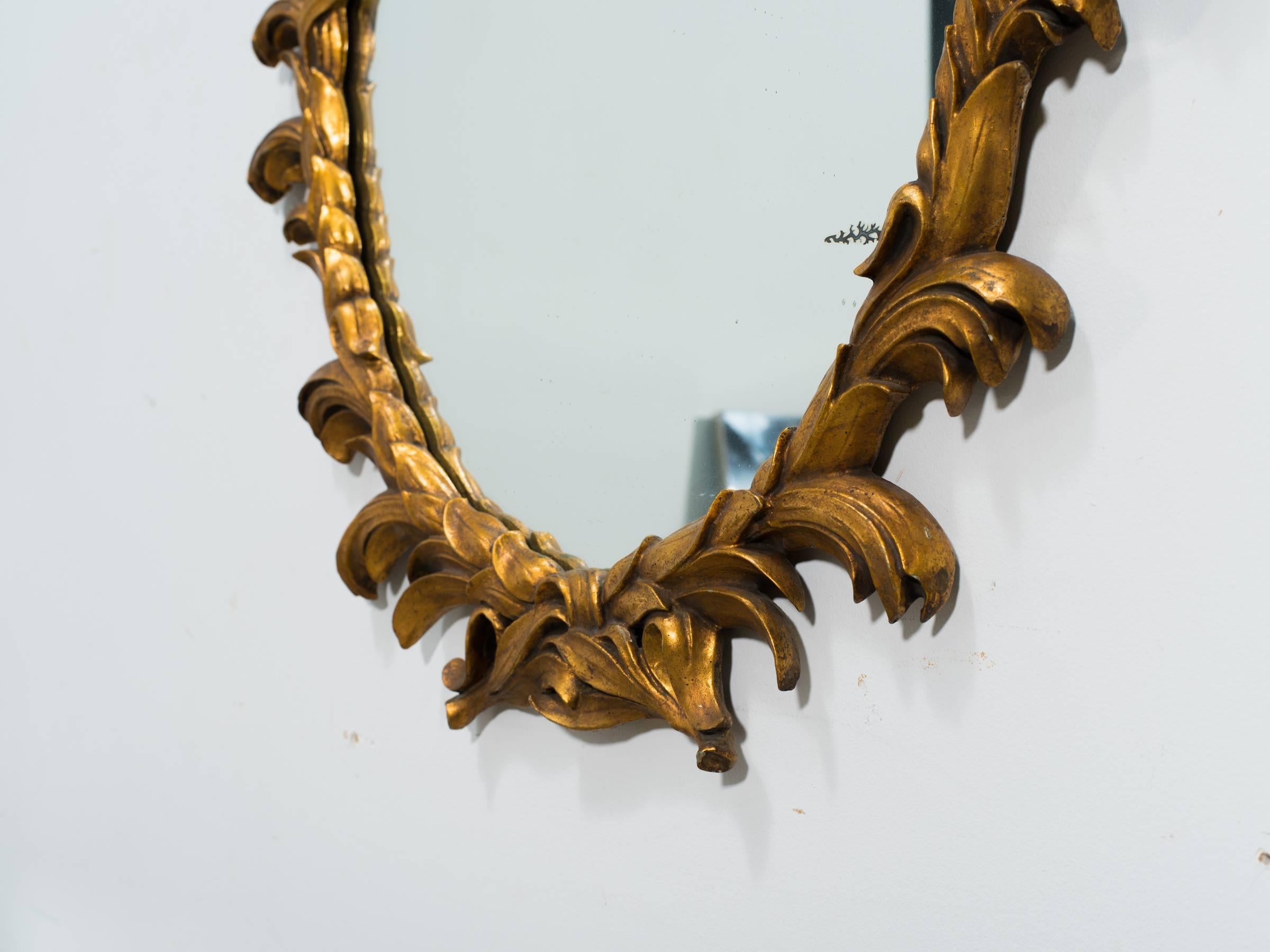 1960s carved giltwood Italian oval mirror.
