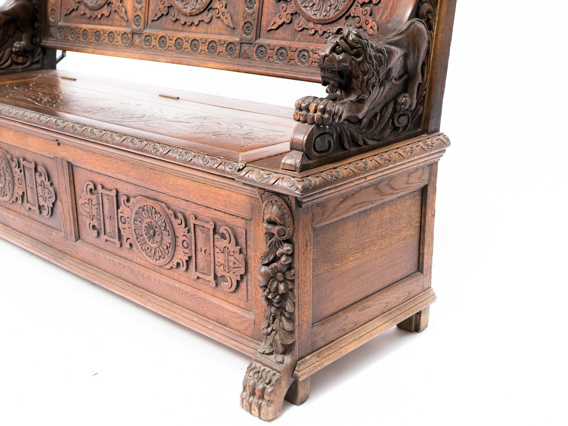 19th century ornately carved bench with storage area.
