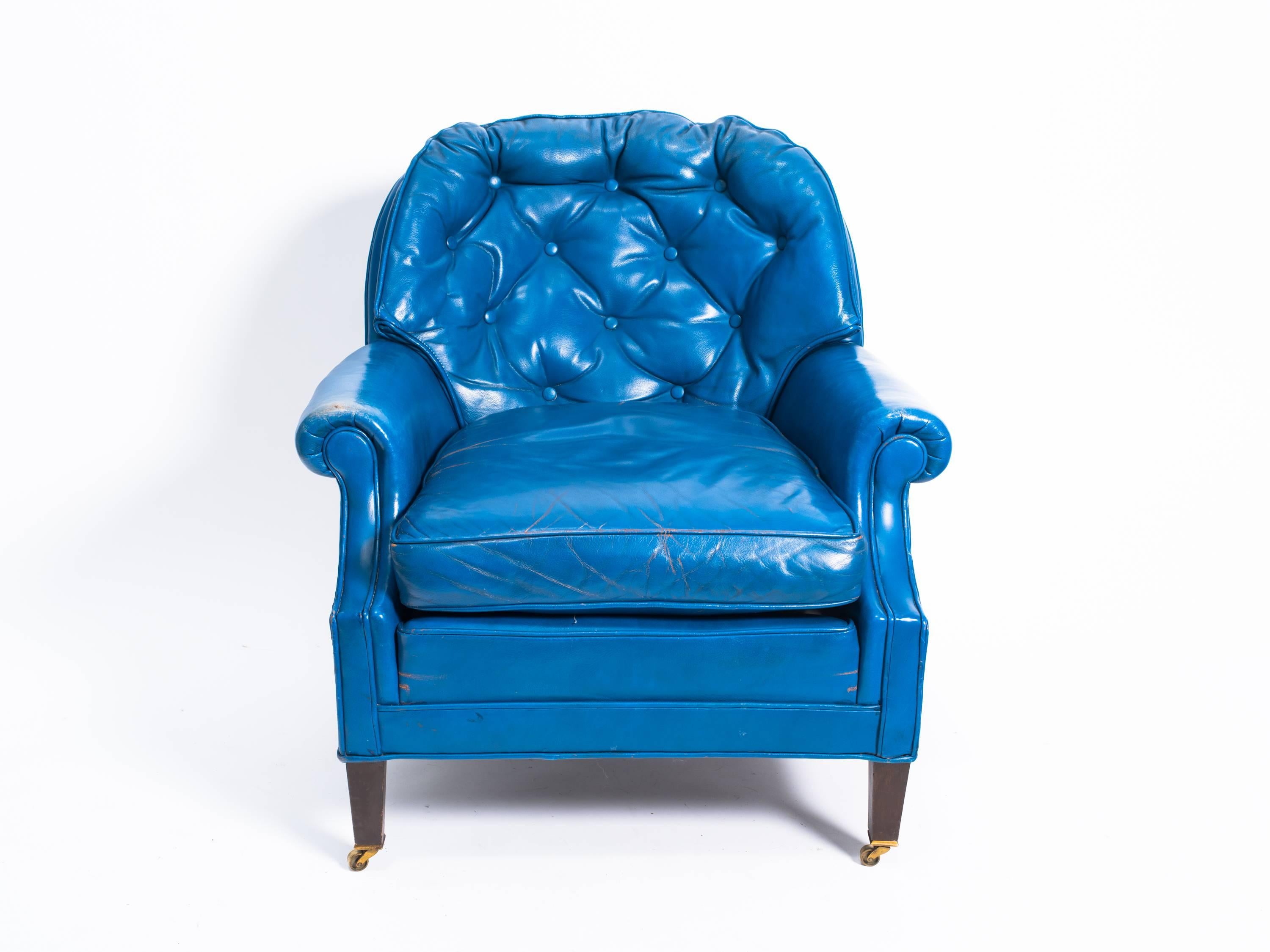 Pair of distressed blue leather lounge chairs with a single ottoman.