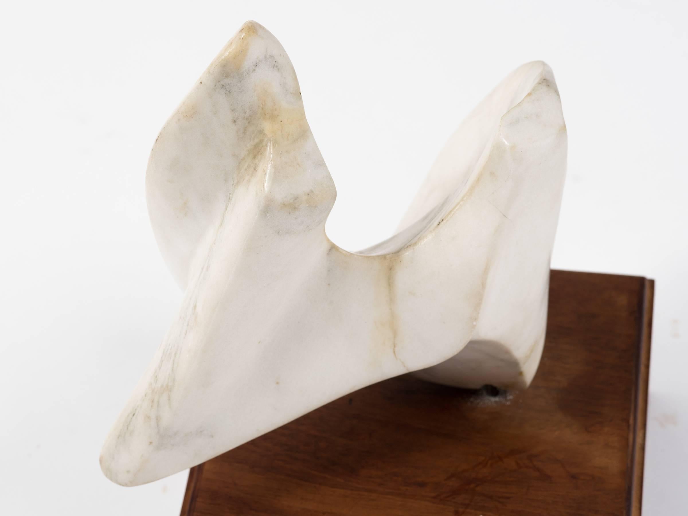 Abstract marble sculpture on wood base.