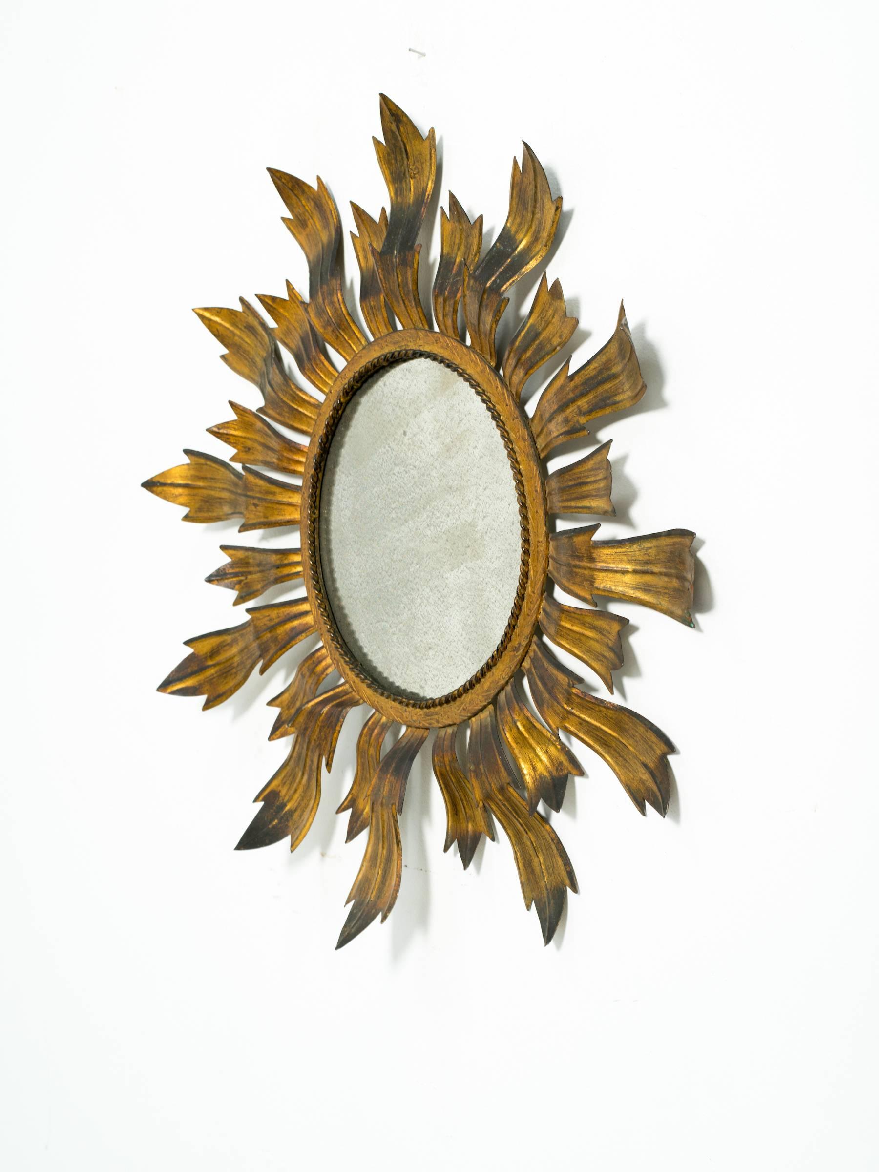 Gilt metal sunburst mirror with aged glass.