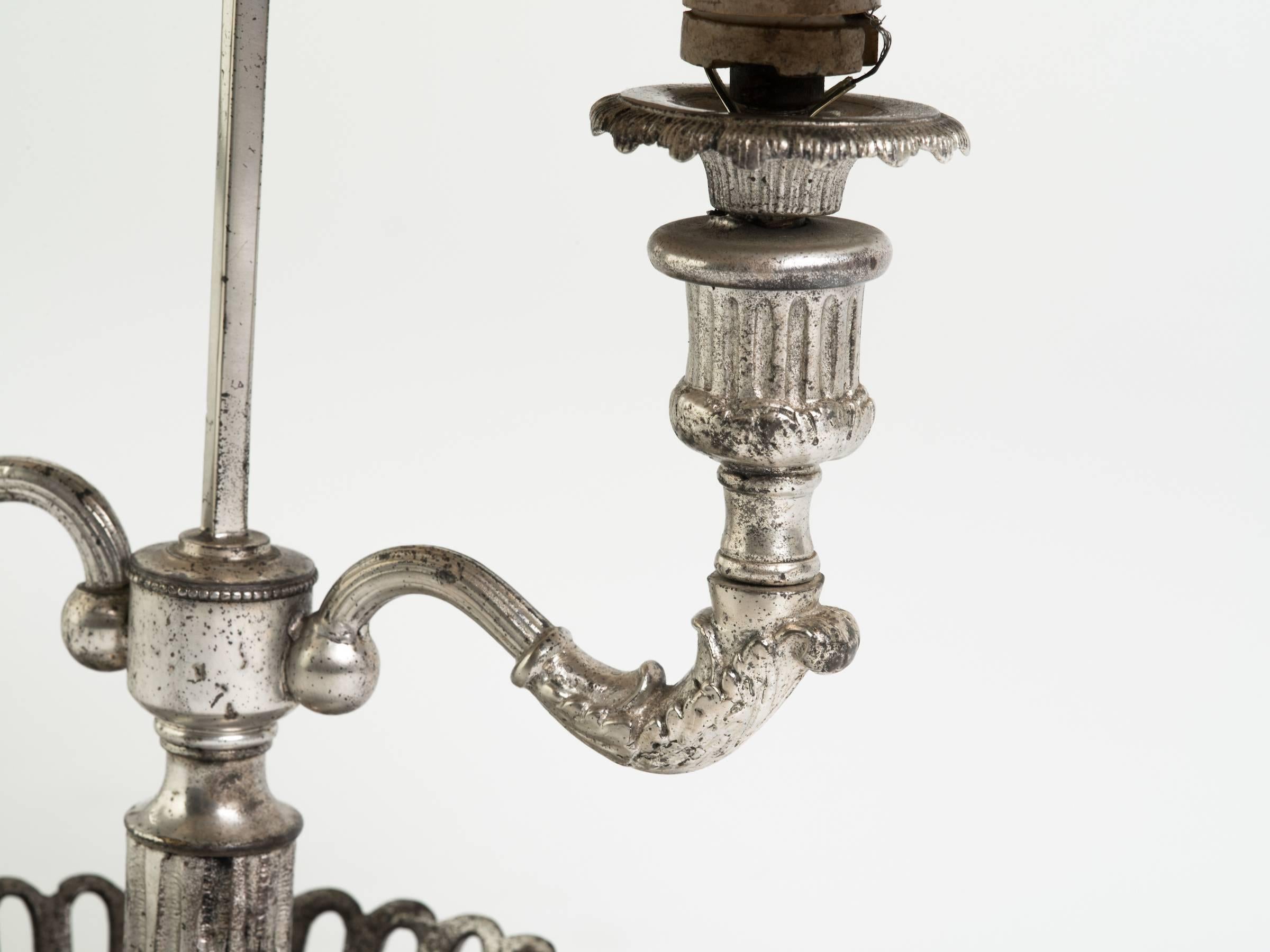 Lampe Bouillotte en métal argenté du début du siècle avec abat-jour en tôle.