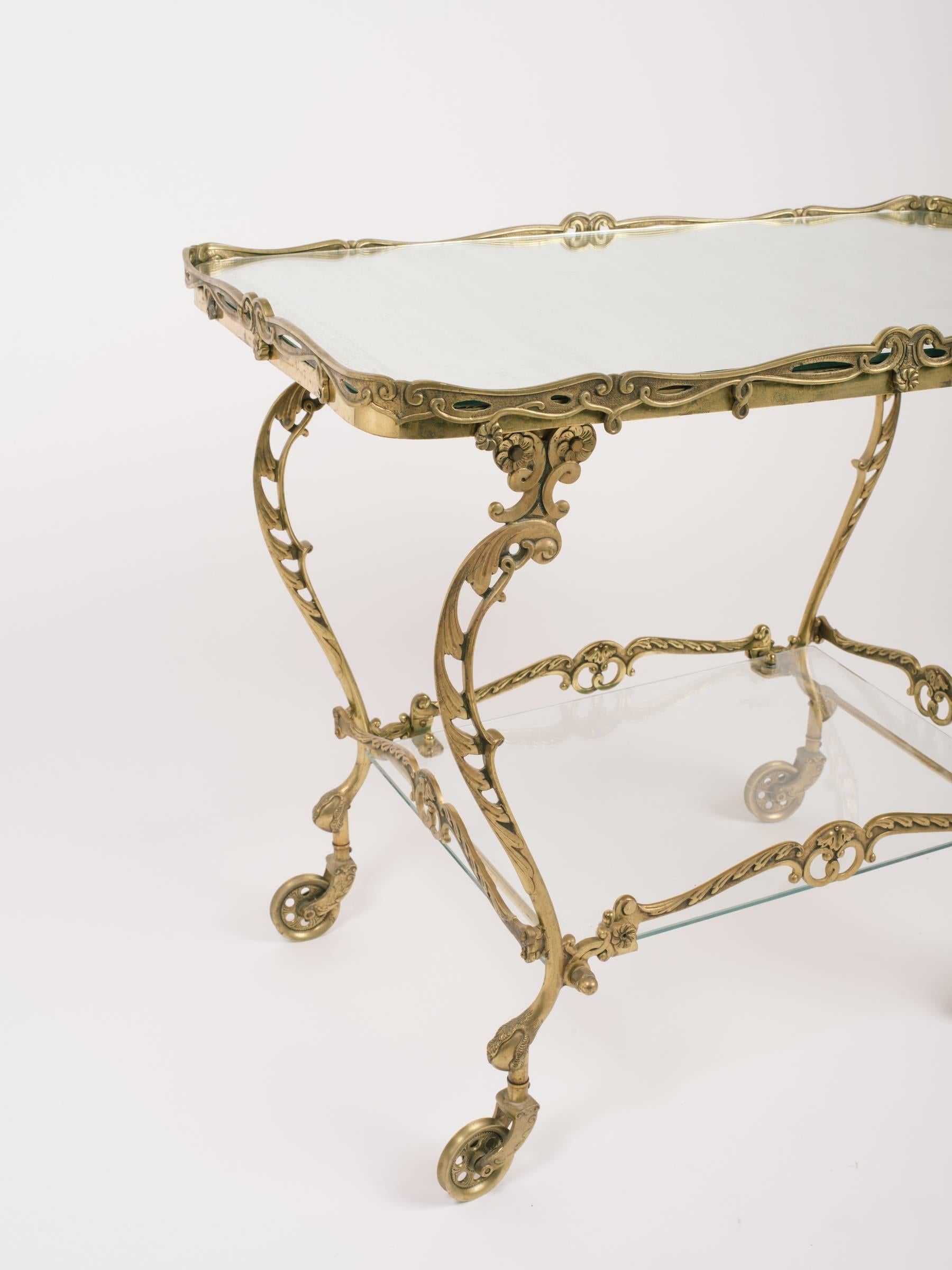 1950s Art Nouveau style brass tea cart made in Portugal from Saks Fifth Avenue. Mirrored top, glass bottom.