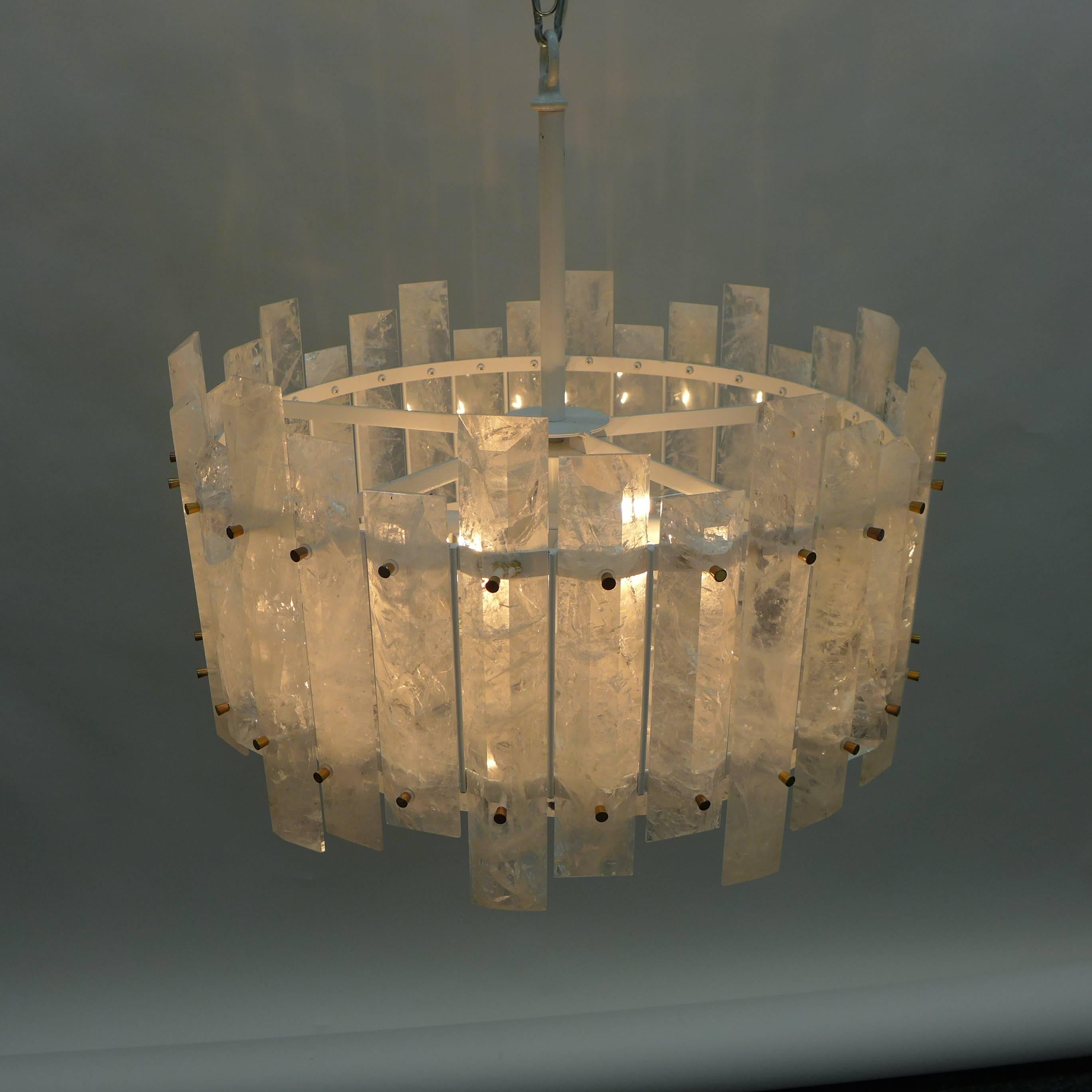Rock crystal chandelier, round frame composed of beveled rectangular quartz elements interspersing three different sizes. Inner circle containing ten triangular crystals with rounded rock crystal finial at the bottom.