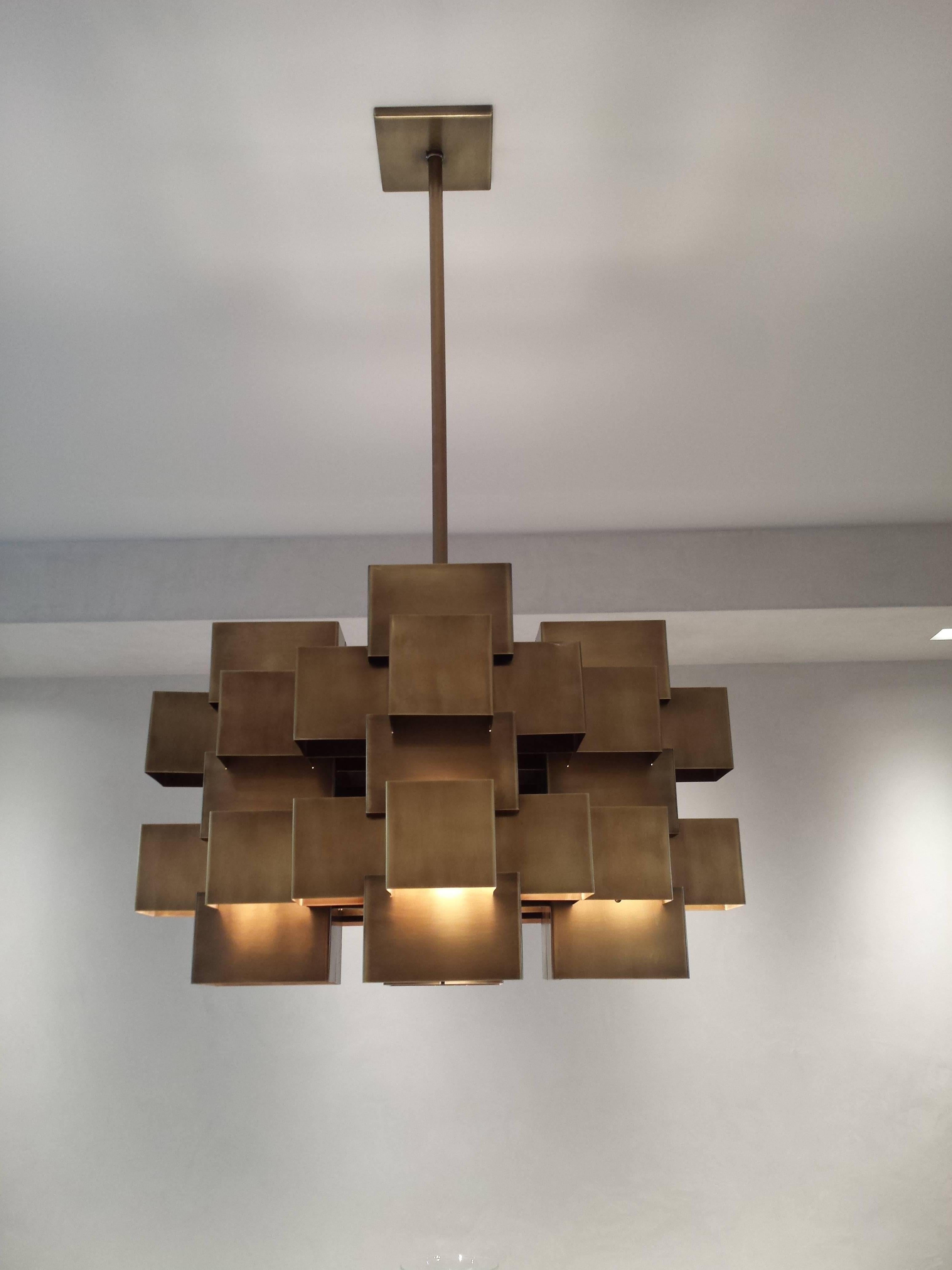 A very elegant and solid cubist chandelier in the manner of Curtis Jere.
Antique brass - 26