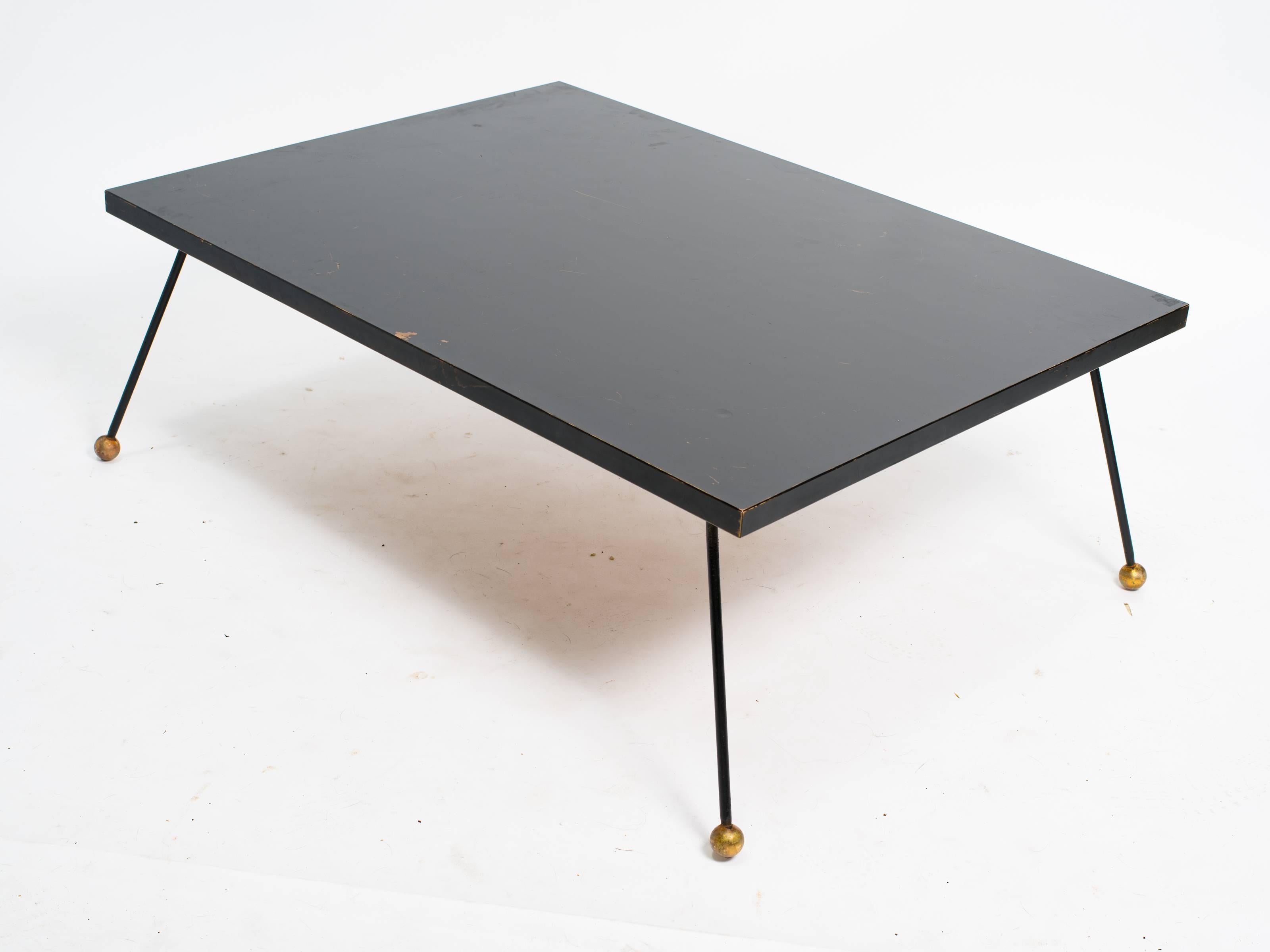 Jean Royère style wood coffee table with iron and brass legs.