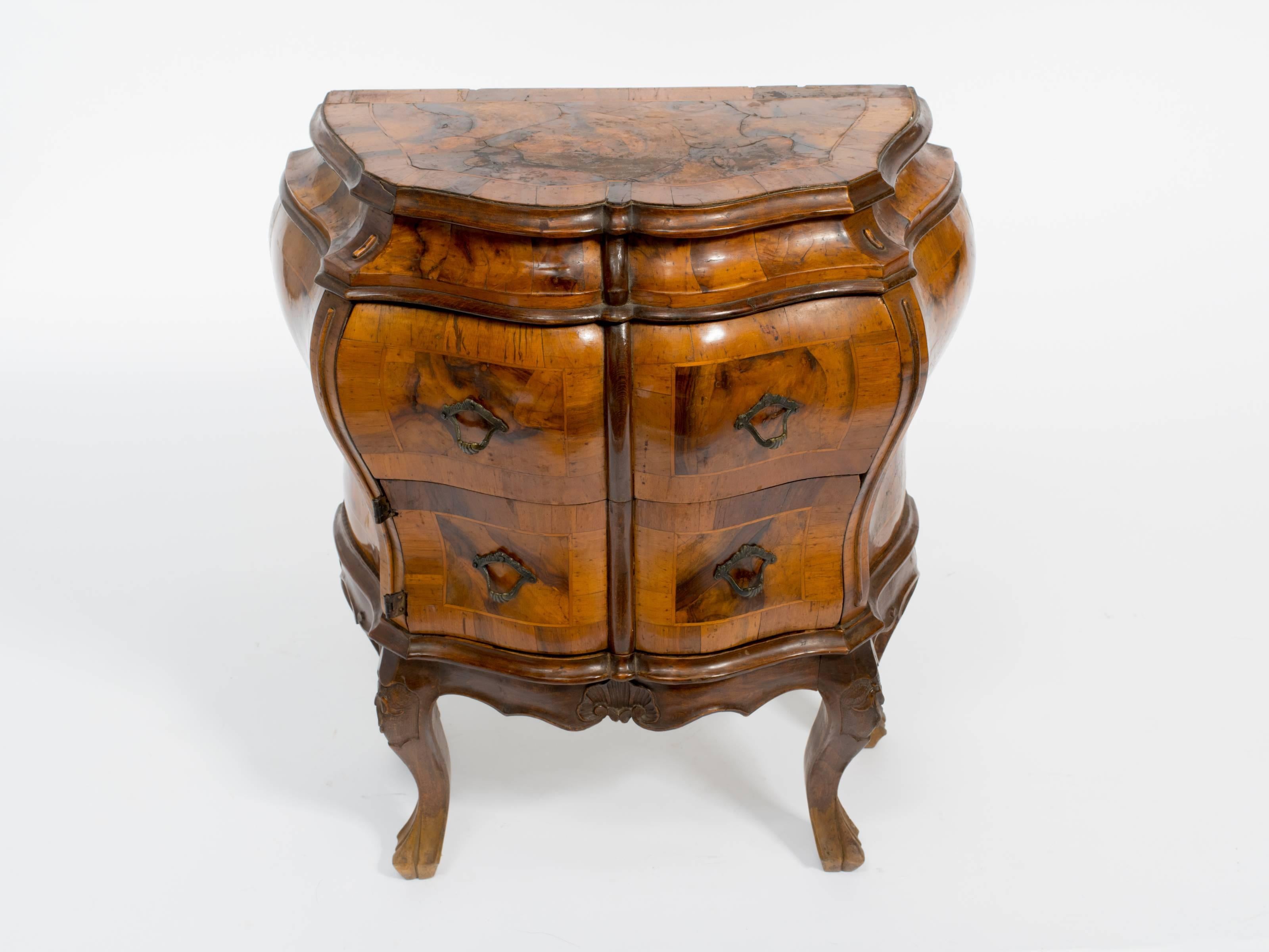 Petite burl bombe cabinet. It has a drawer and cabinet section.