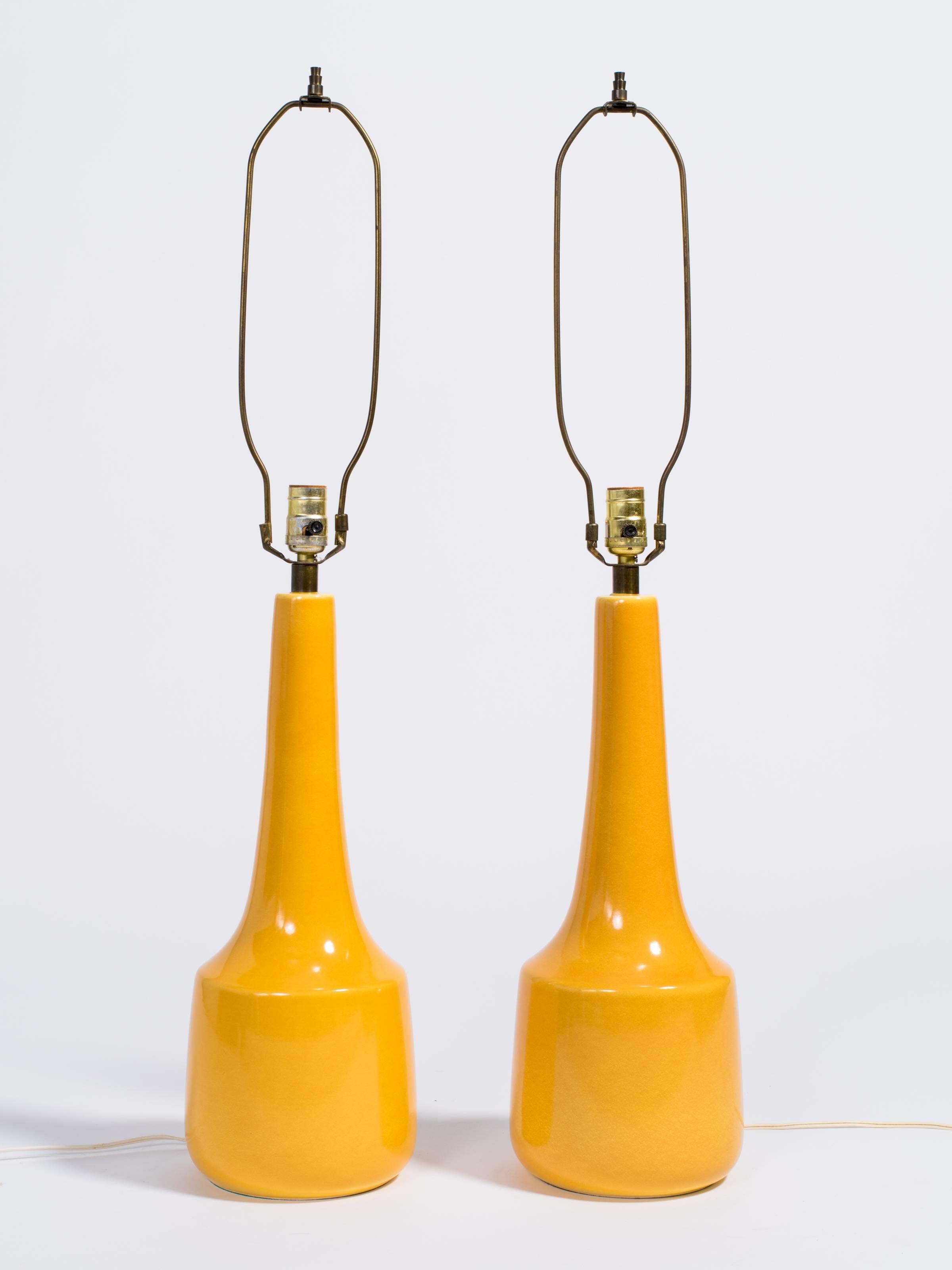 Pair of yellow ceramic lamps designed by Lotte and Gunnar Bostlund. They have the original shades.