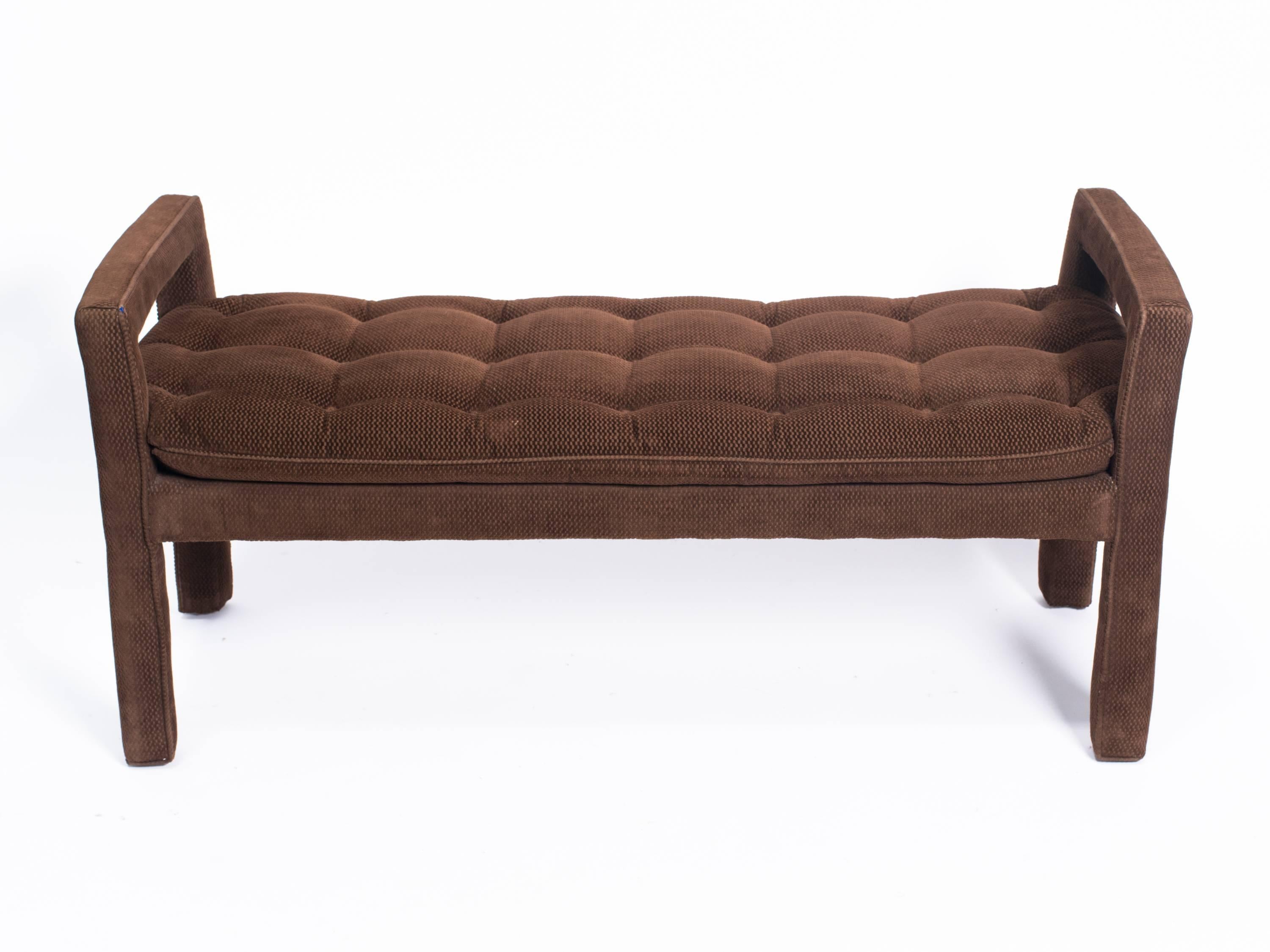 Long upholstered tufted bench in brown.