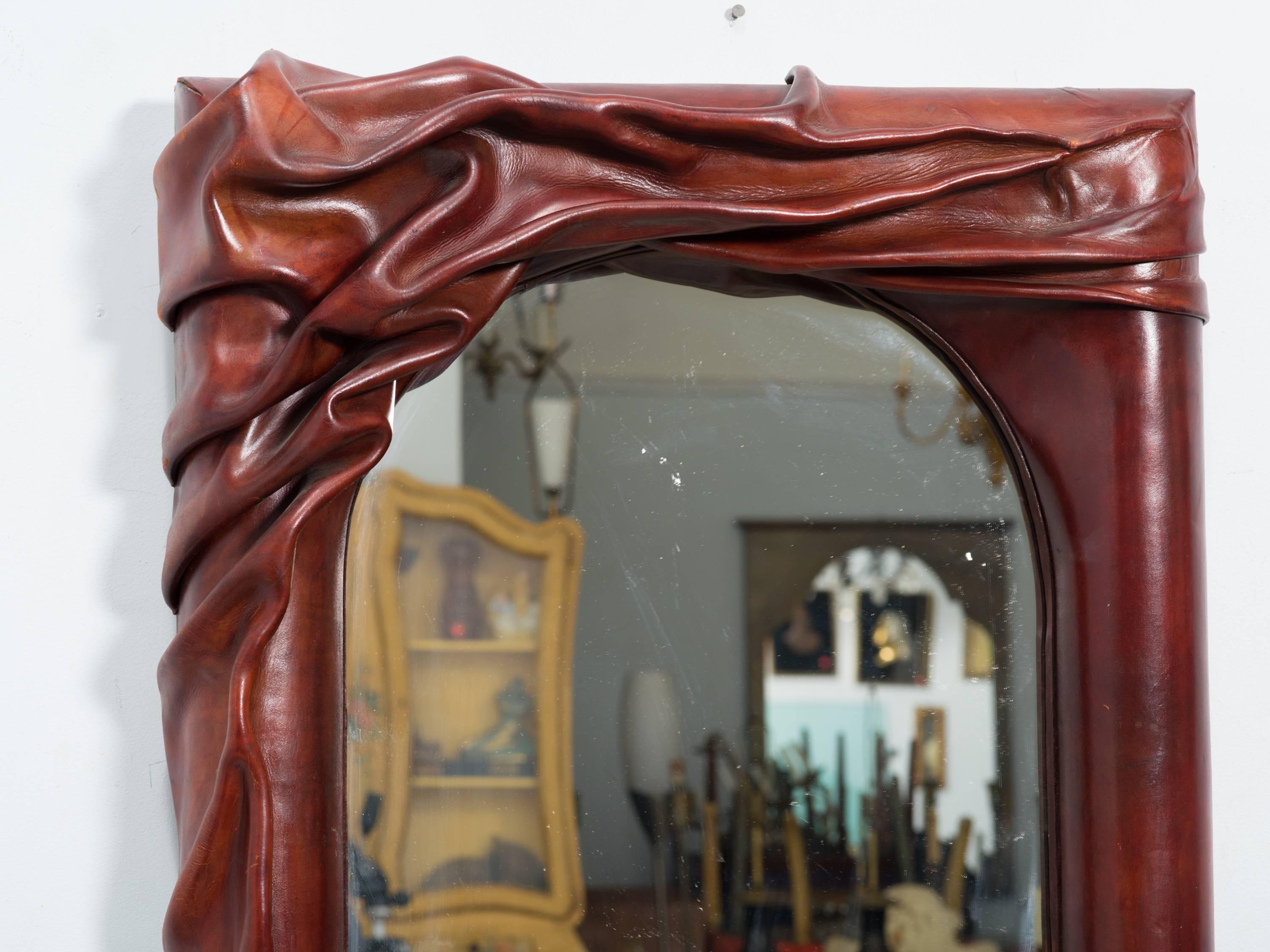 Sculptural leather wall mirror.