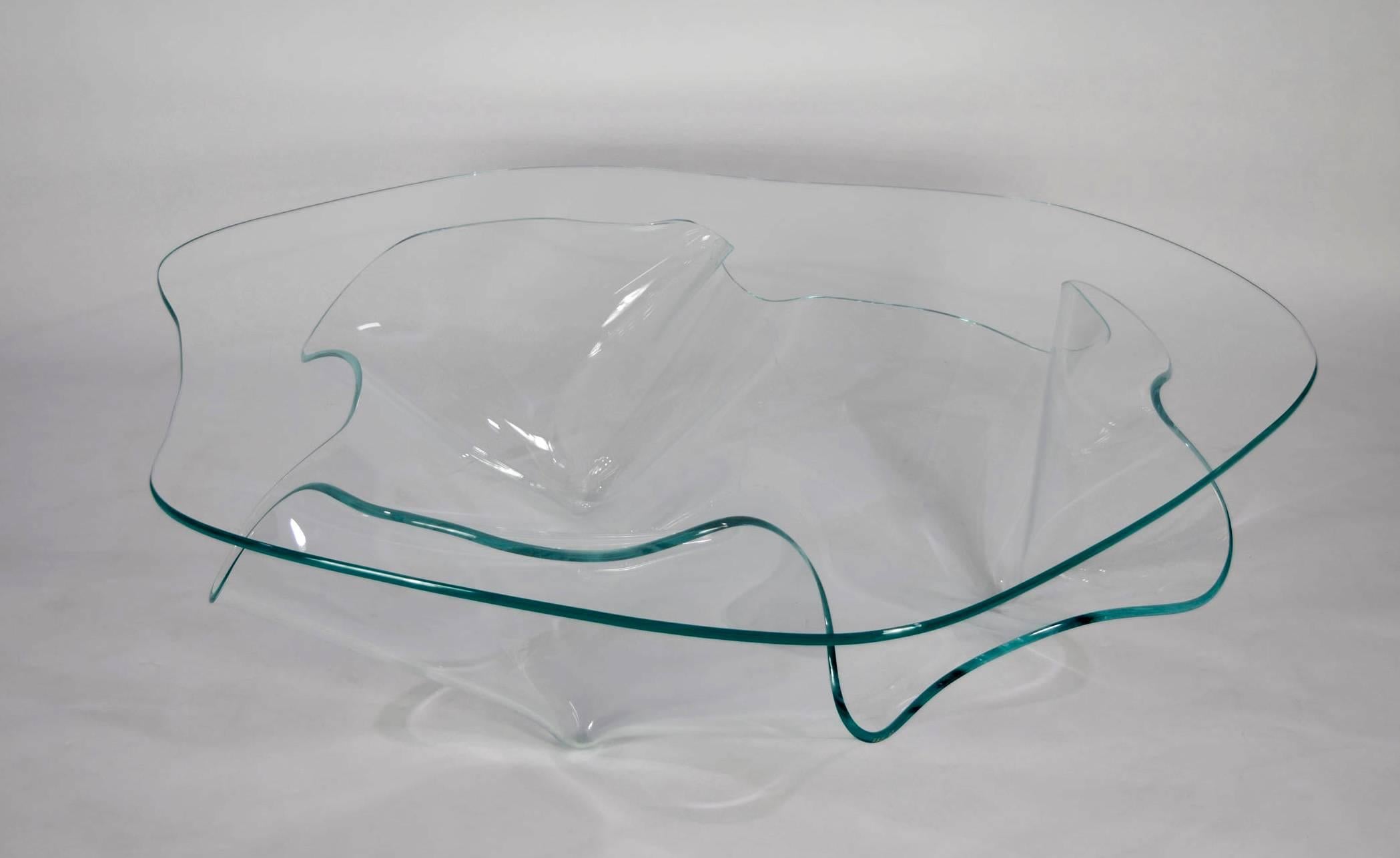 A gorgeous sculptural glass coffee table by Laurel Fyfe (d. 2011). Laurel founded Fox Fires Industries which continues to make high-end architectural glass and is known for their ability to bend glass. Table is signed in gold 