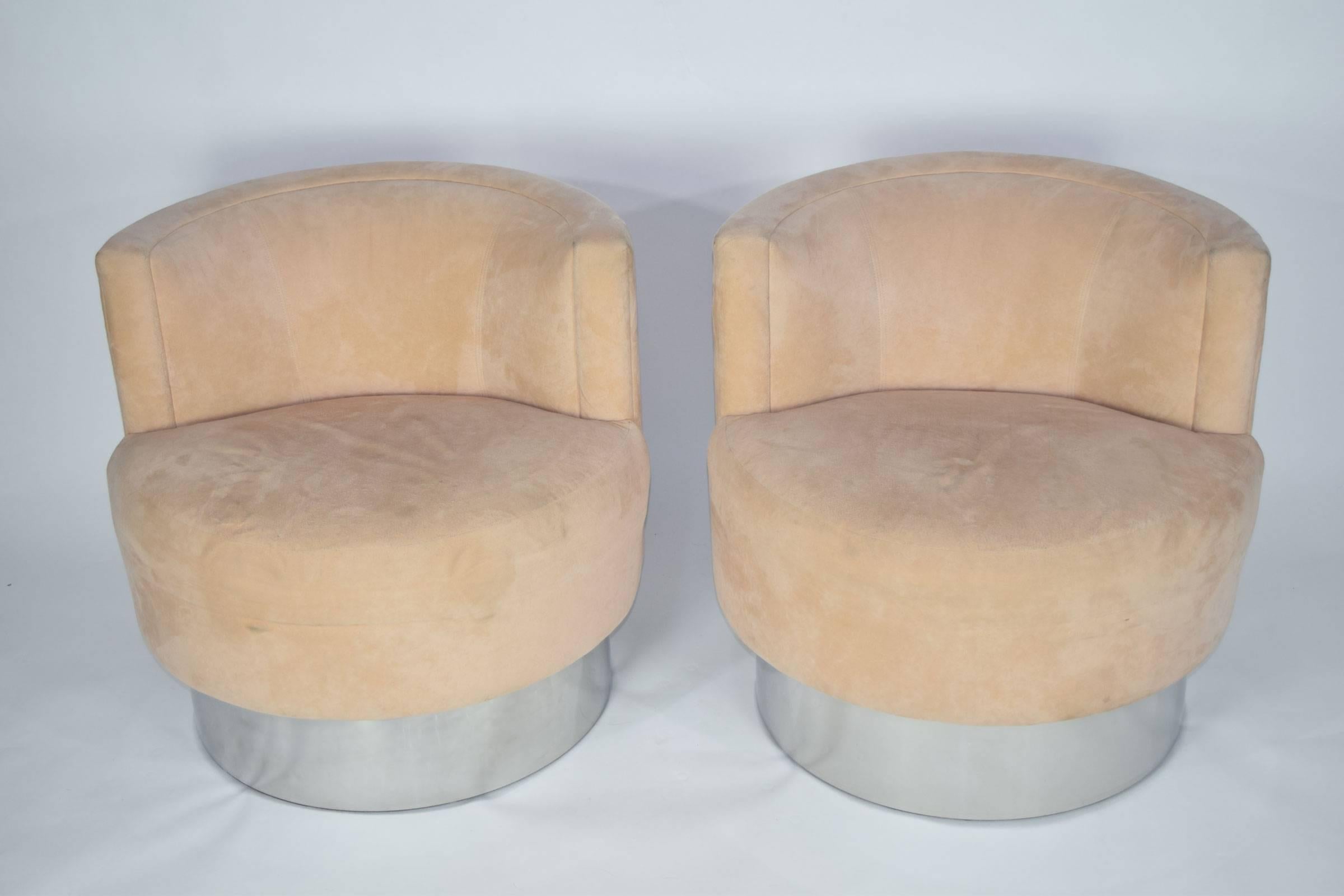 A great pair of Milo Baughman lounge chairs. They swivel and are raised on a chrome base. We have not recovered but buyer can chose an exciting fabric. We can help with reupholstery if needed. We can also change the base to a brass finish if