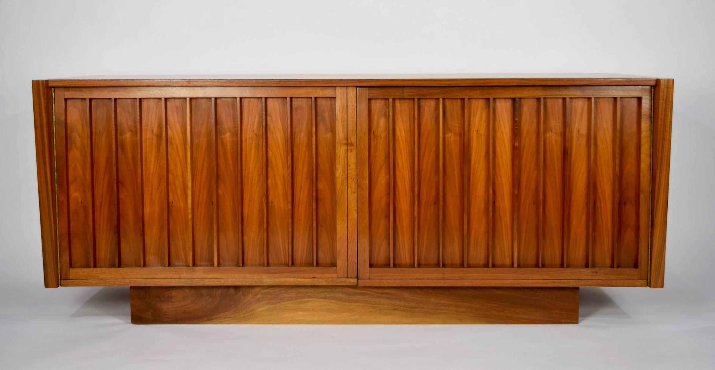 A beautiful cabinet or sideboard by George Nakashima for Widdicomb. In Sundra walnut with curved top and bowed doors that open to reveal three drawers and shelving on both sides. Nakashima signature intact along with Widdicomb label.