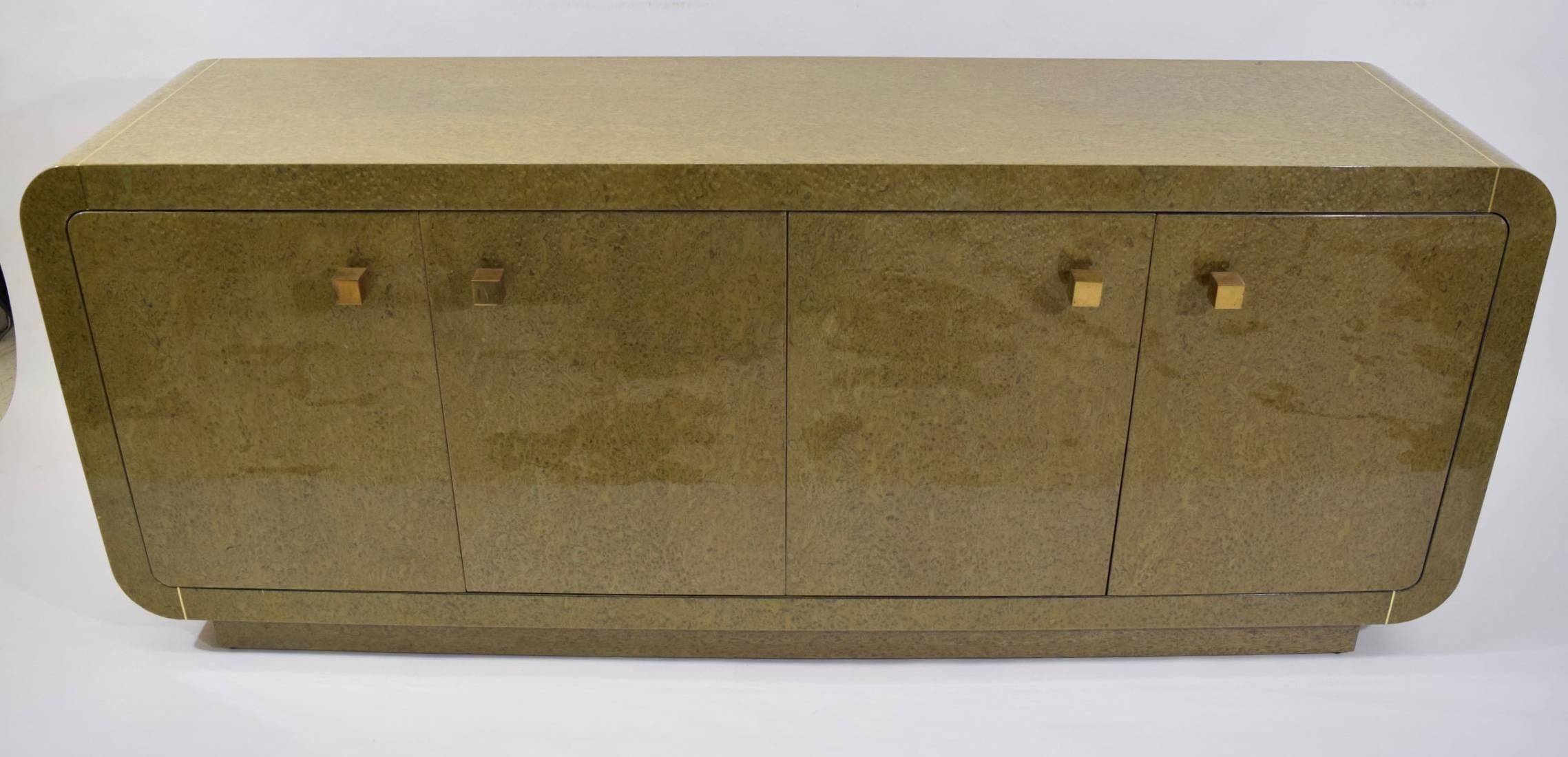 The finish on this is beautiful and exceptional. It is a high gloss bird's-eye style lacquer with brass inlay. Knobs are brass cubes. The credenza is in excellent condition accept for two small marks on the side. We can have these expertly repaired