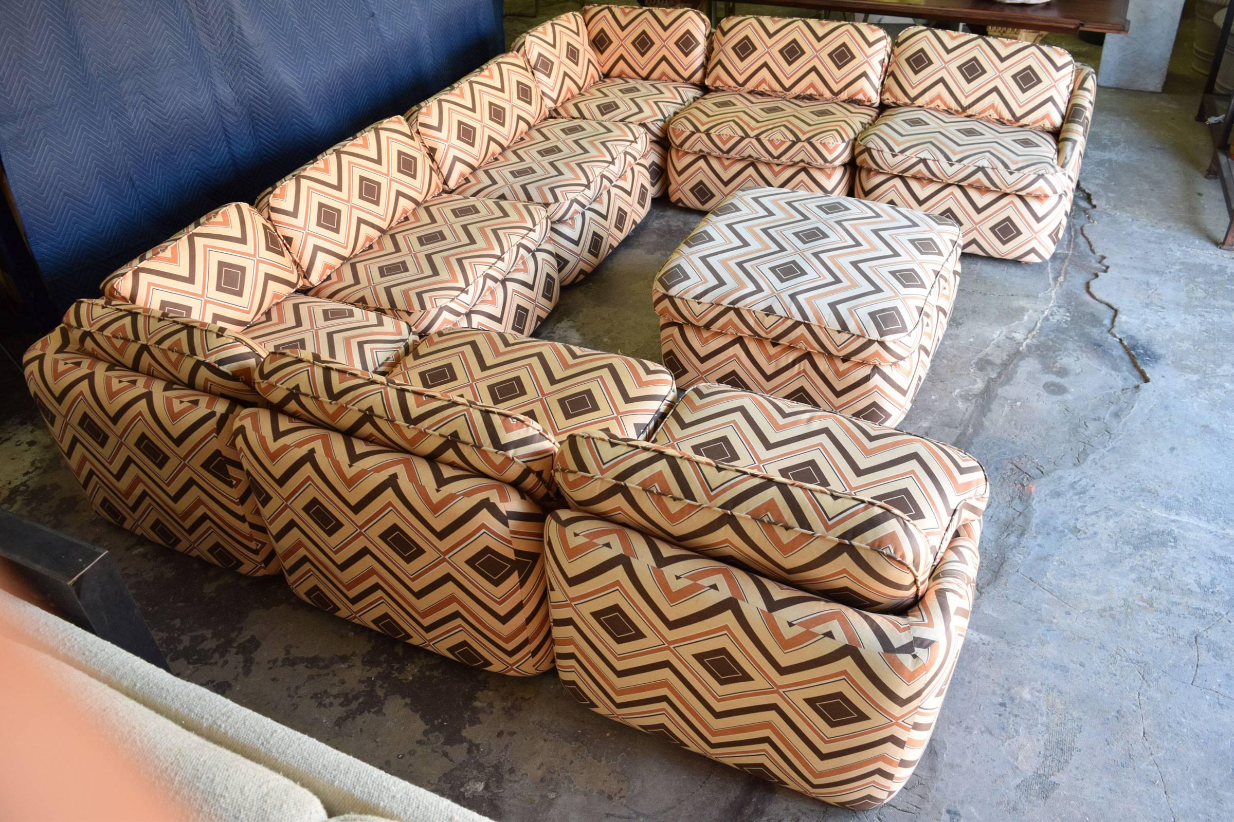 Versatile nine piece sectional in the style of Milo Baughman. Eight pieces plus an ottoman. Two corner pieces, two end pieces and four armless pieces. Dimensions posted or as presented in photo. The corner pieces are 33