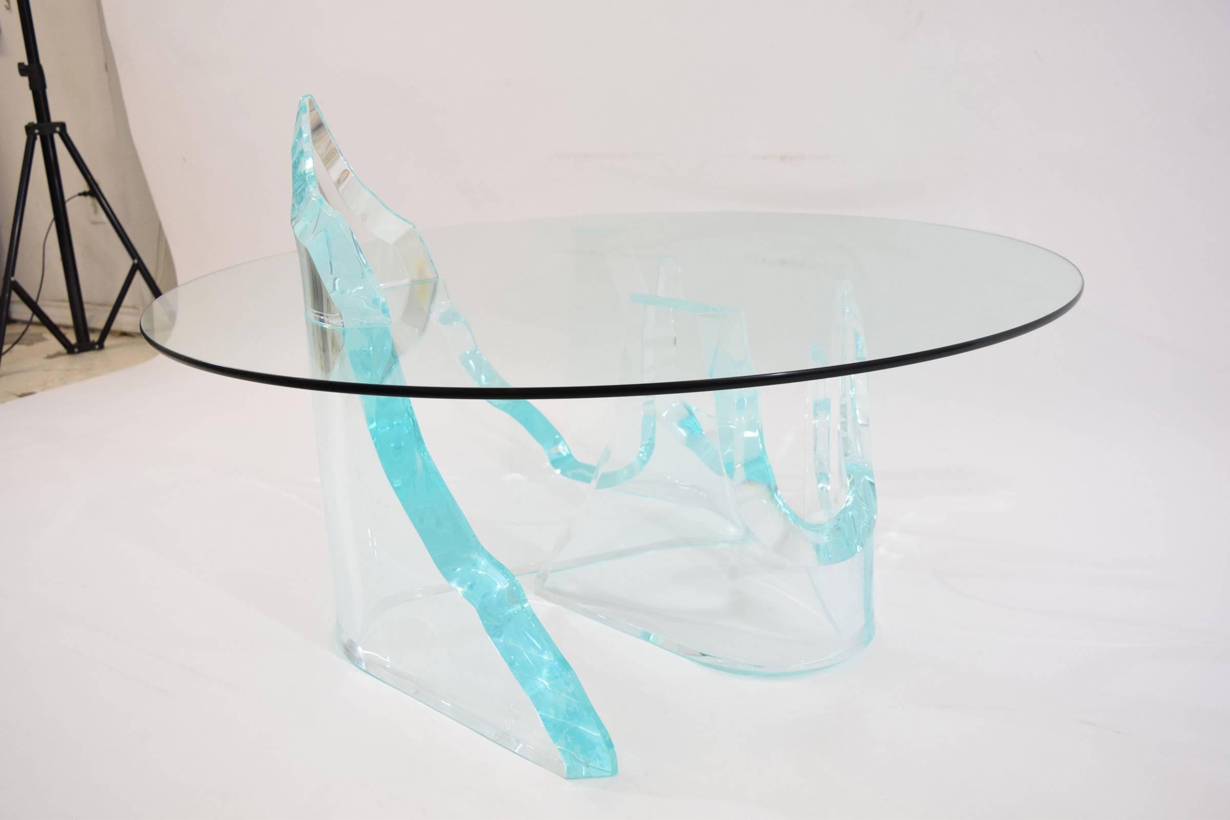 This table has two thick Lucite bases with a turquoise reflection. The bases can accommodate a larger piece of glass if desired. There is one cap that sits on top of the glass and the can be removed. Table has "Lion in Frost" signature.