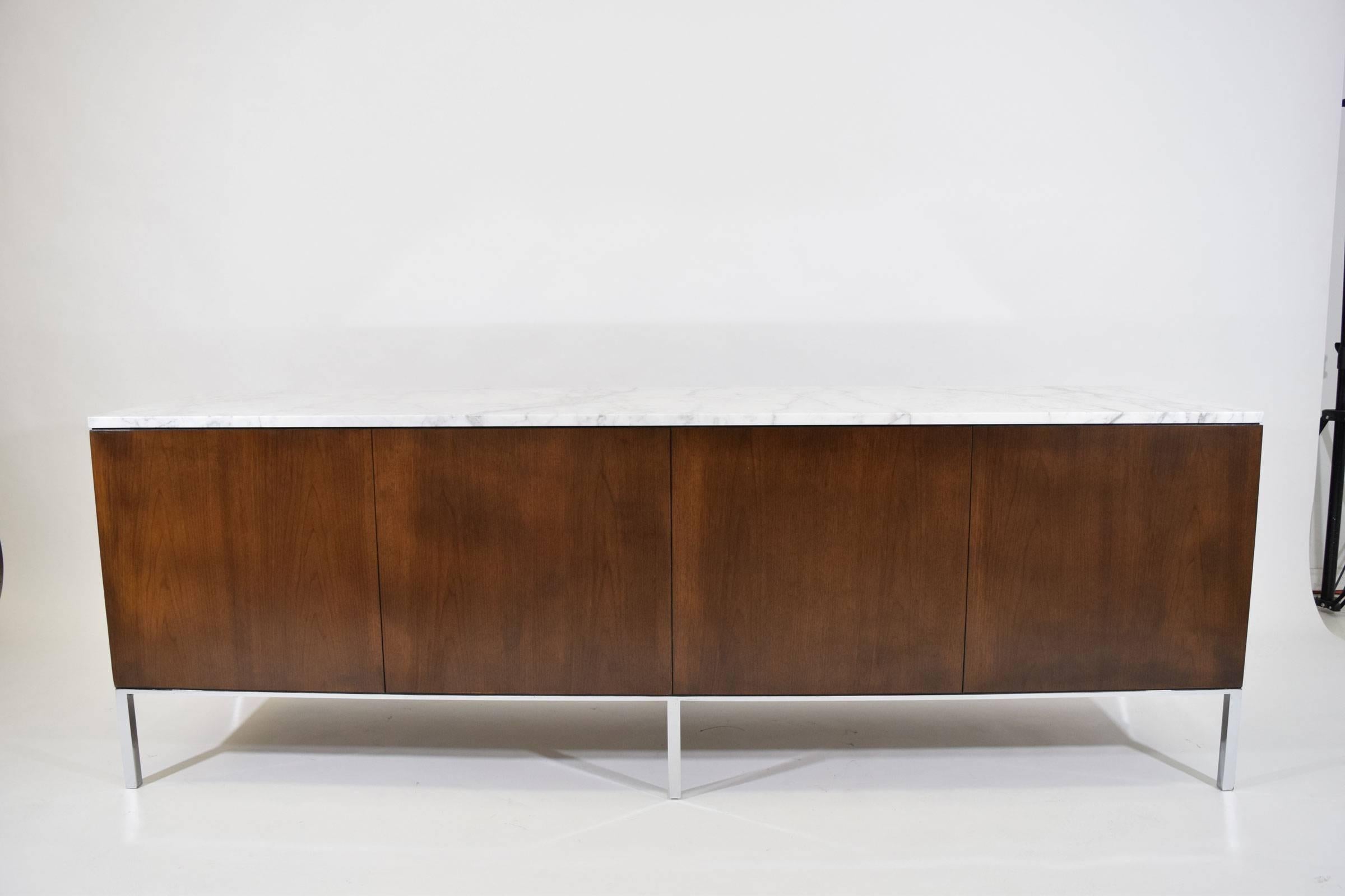 This is an early Florence Knoll credenza. The back is finished so the piece can float if desired. We have restored o the piece is in beautiful condition. Top is Statvario Venato marble. Four sections include three doors with shelves and a set of