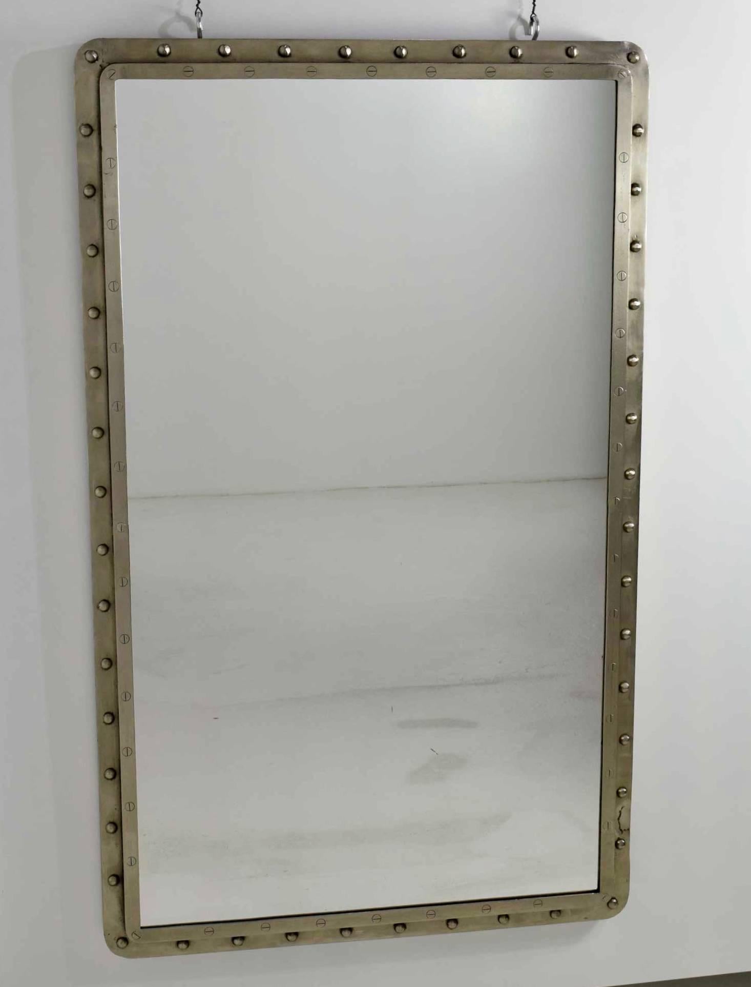Very large Industrial style iron wall mirrors. Mirrors have rivets with screws around edge, two level frames. Brushed silver metal. Mirrors do not have rings on top, we placed there for the photo. Can be hung flat against a wall either horizontally