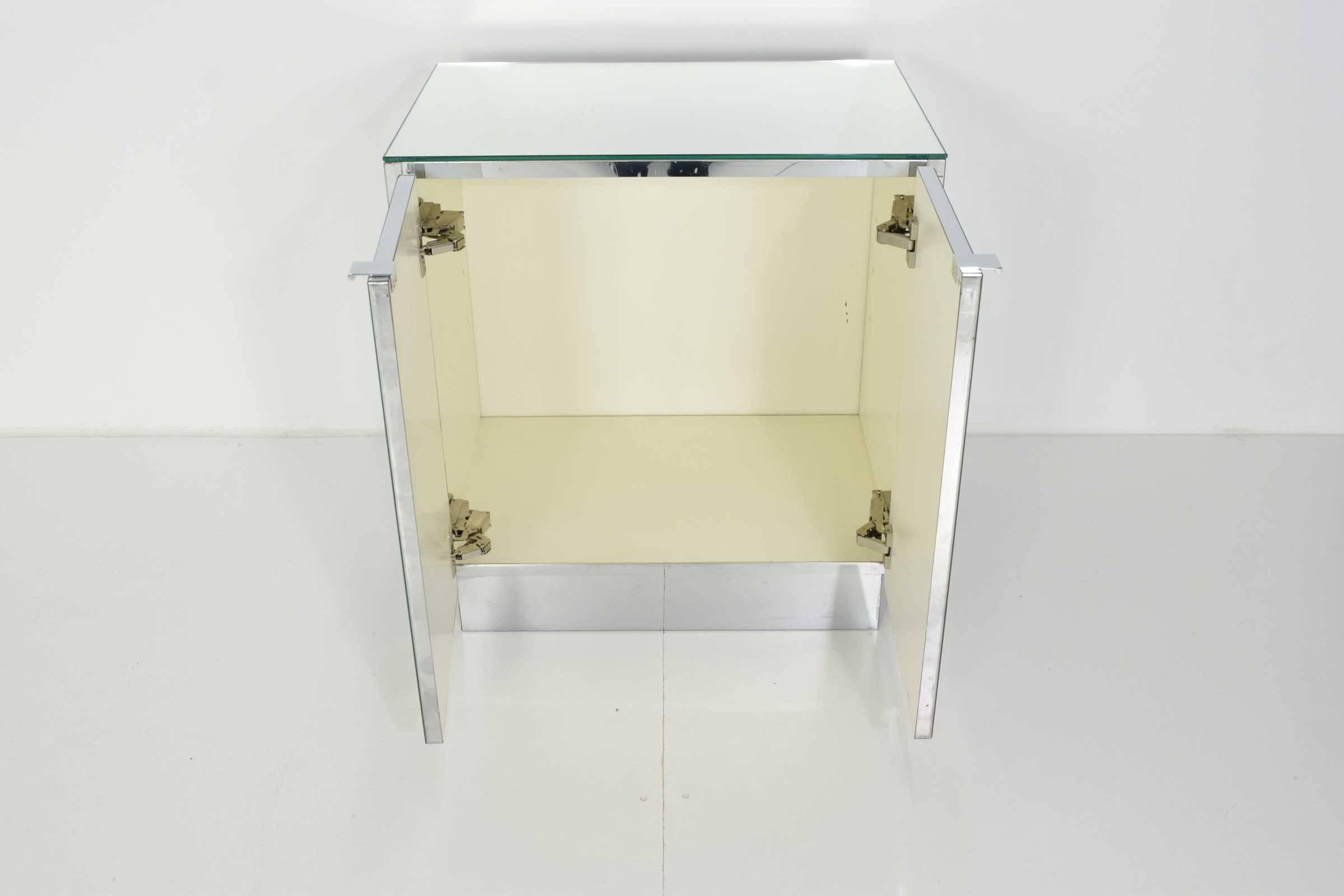 Very nice two-door mirrored chest/side table/nightstand by Ello Furniture Company. Top and front are mirrored, sides and base are chrome. We have a three door chests that compliments this very nicely and both can be used as nightstands.