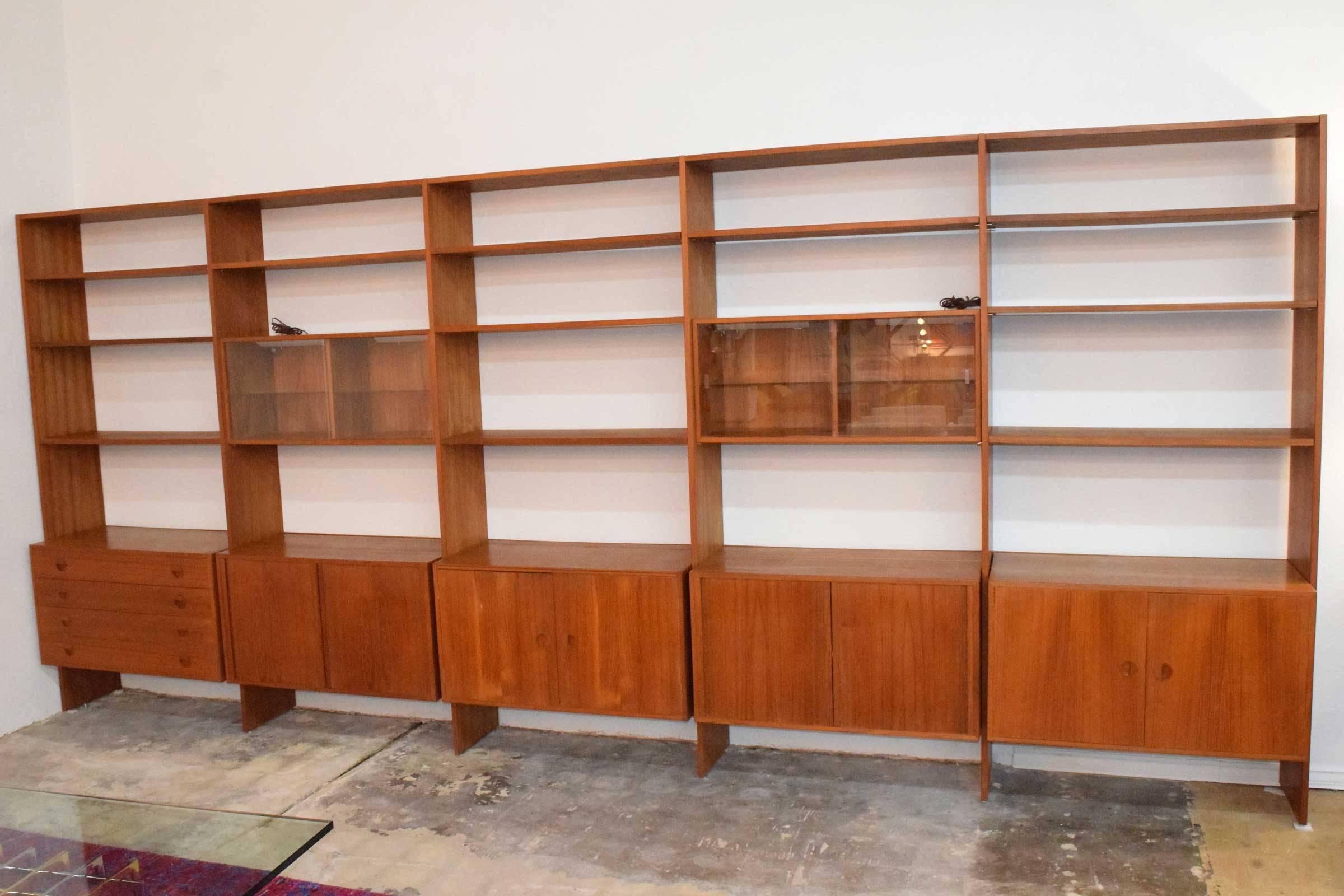 Large teak modular wall unit by HG Furniture (Hansen & Guldborg). Unit is five sections and can be assembled in two, three, four or five sections. Two storage compartments with sliding glass fronts and working lighting. This unit has tons of