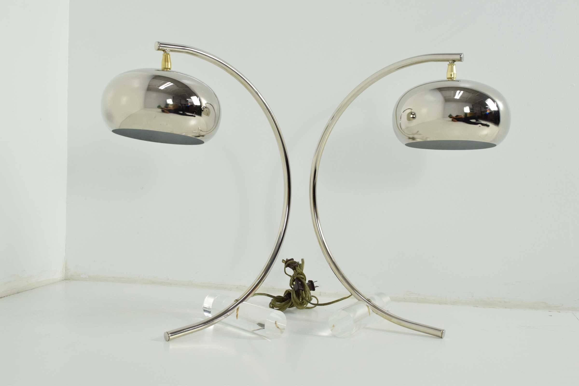 A unique pair of table lamps with nickel finish and Lucite base.